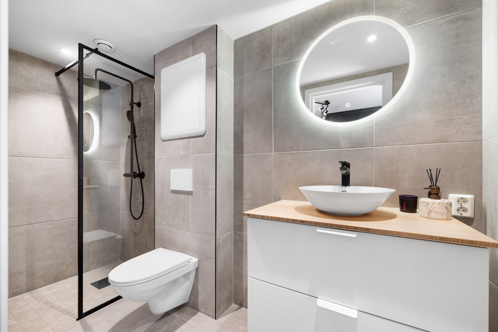 Flott helfliset bad med vegghengt toalett, benkeskap med servant og dusjvegg i glass. Galleribilde