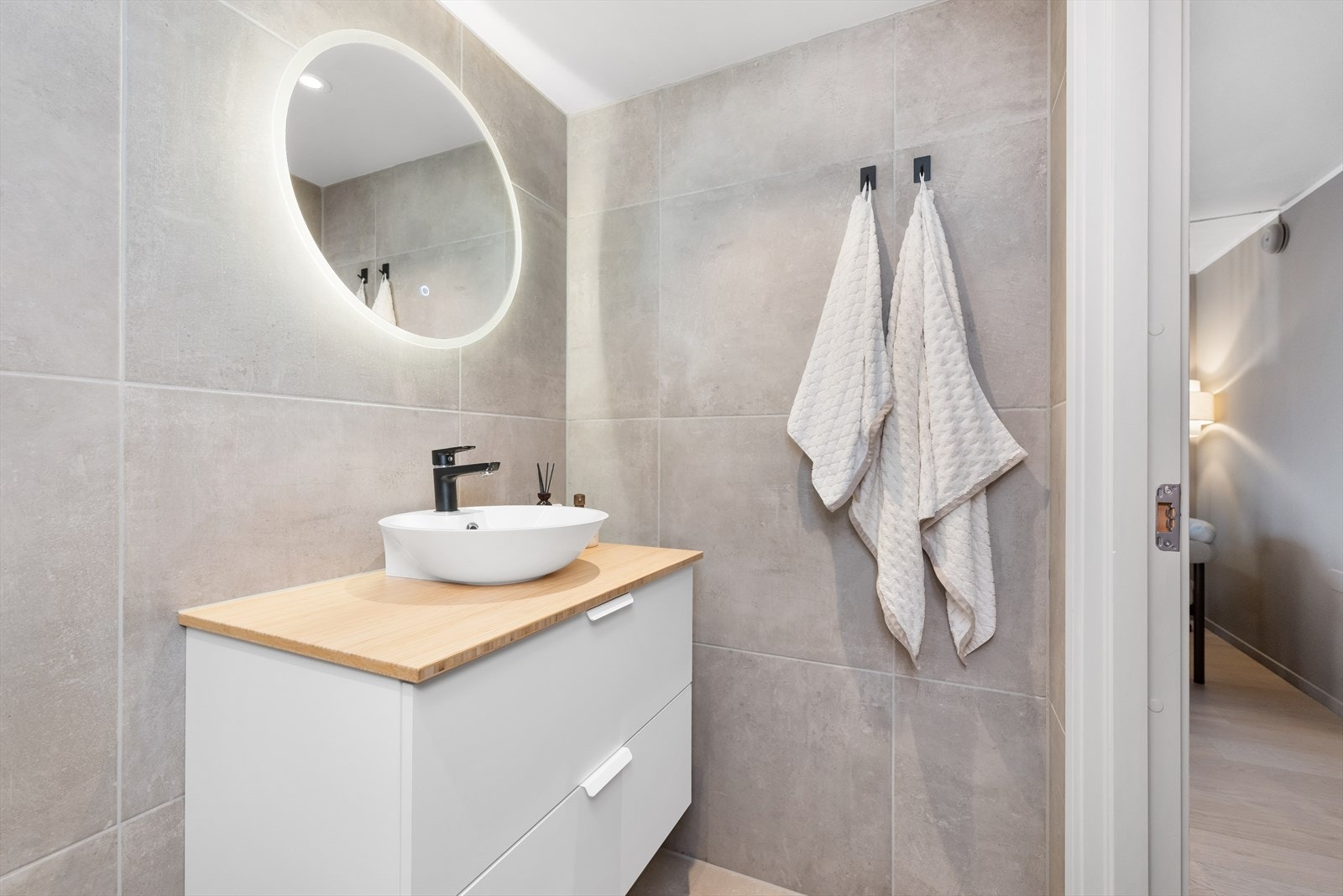 Moderne baderomsinnredning med gode oppbevaringsmuligheter under. Galleribilde