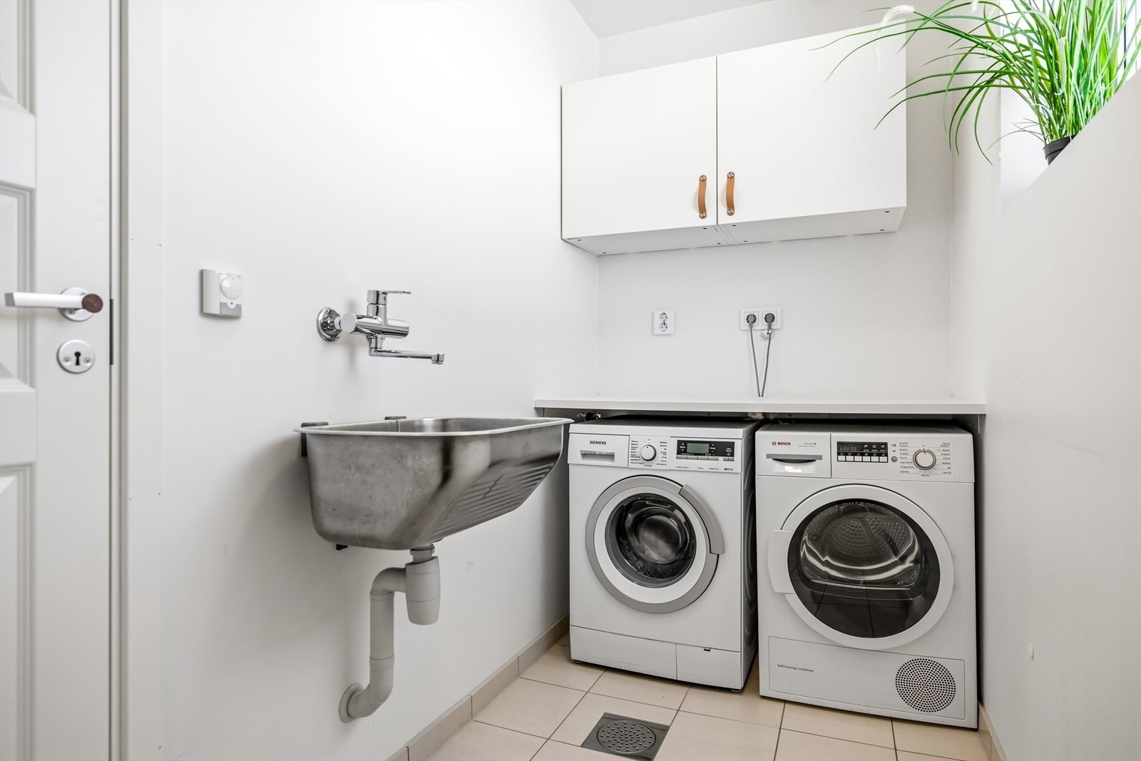 Vegg i vegg med badet ligger et praktisk vaskerom med plass til både vaskemaskin og tørketrommel. Galleribilde