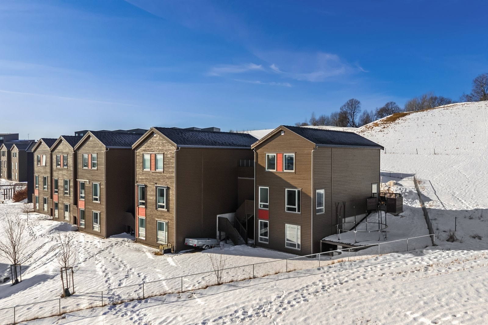 På enden av huset er det platting med plass til trampoline. Fellesområdet er inngjerdet og er et trygt og fint sted å leke. Galleribilde
