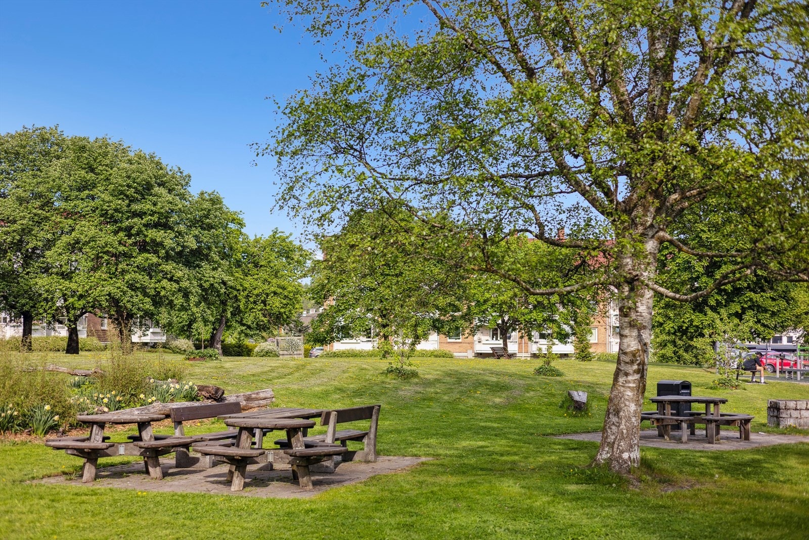 De parkmessig opparbeidede fellesarealene gir et innbydende og velstelt inntrykk, med vakre blomsterbed, stier og sitteplasser som inviterer til avslapning og sosialt samvær. Galleribilde