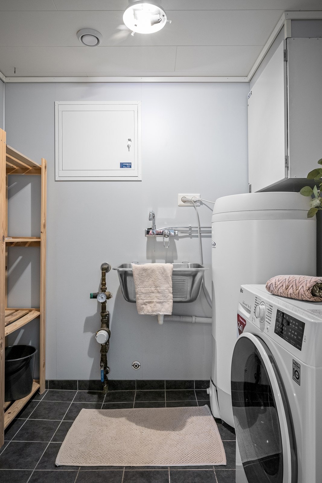 Separat vaskerom med utslagsvask og opplegg for vaskemaskin. Her er også varmtvannsberederen plassert. Galleribilde