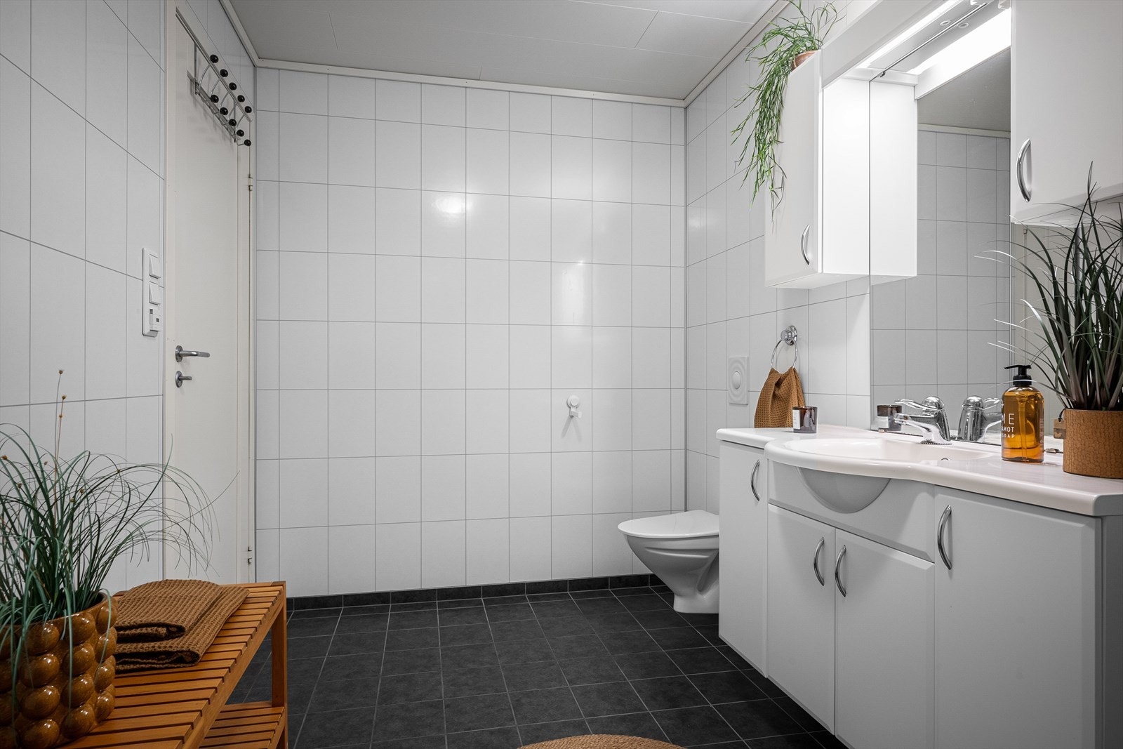 Badet har flislagt gulv med gulvvarme og våtromsplater på veggene. Galleribilde