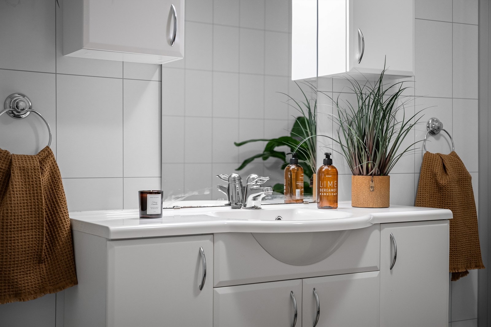 Hvit baderomsseksjon med servant, samt overskap og speil for god oppbevaring. Galleribilde