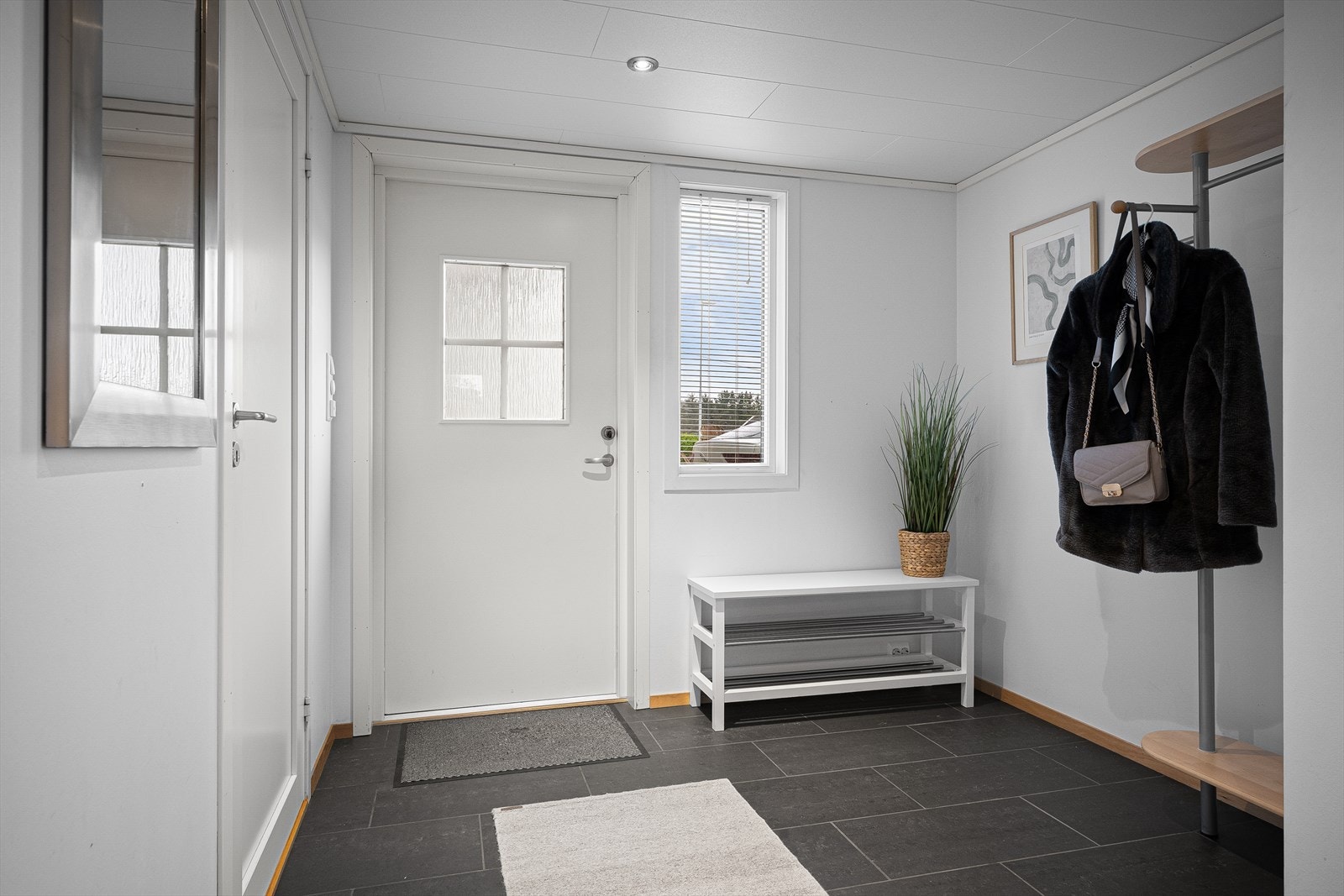 Entréen har praktiske fliser på gulvet og gir tilgang til alle rom i boligen. Galleribilde