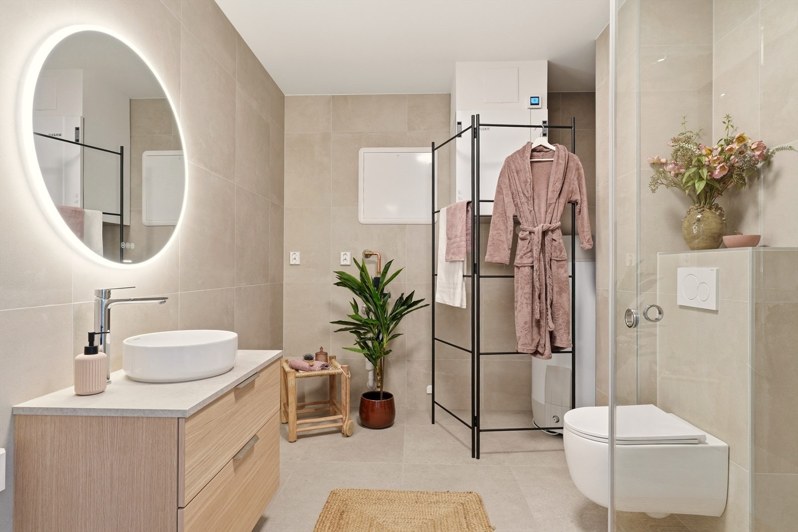 Nydelig og delikat bad som består av innredning med servant, veggmontert toalett, dusjvegger/hjørne og opplegg for vaskemaskin. Galleribilde