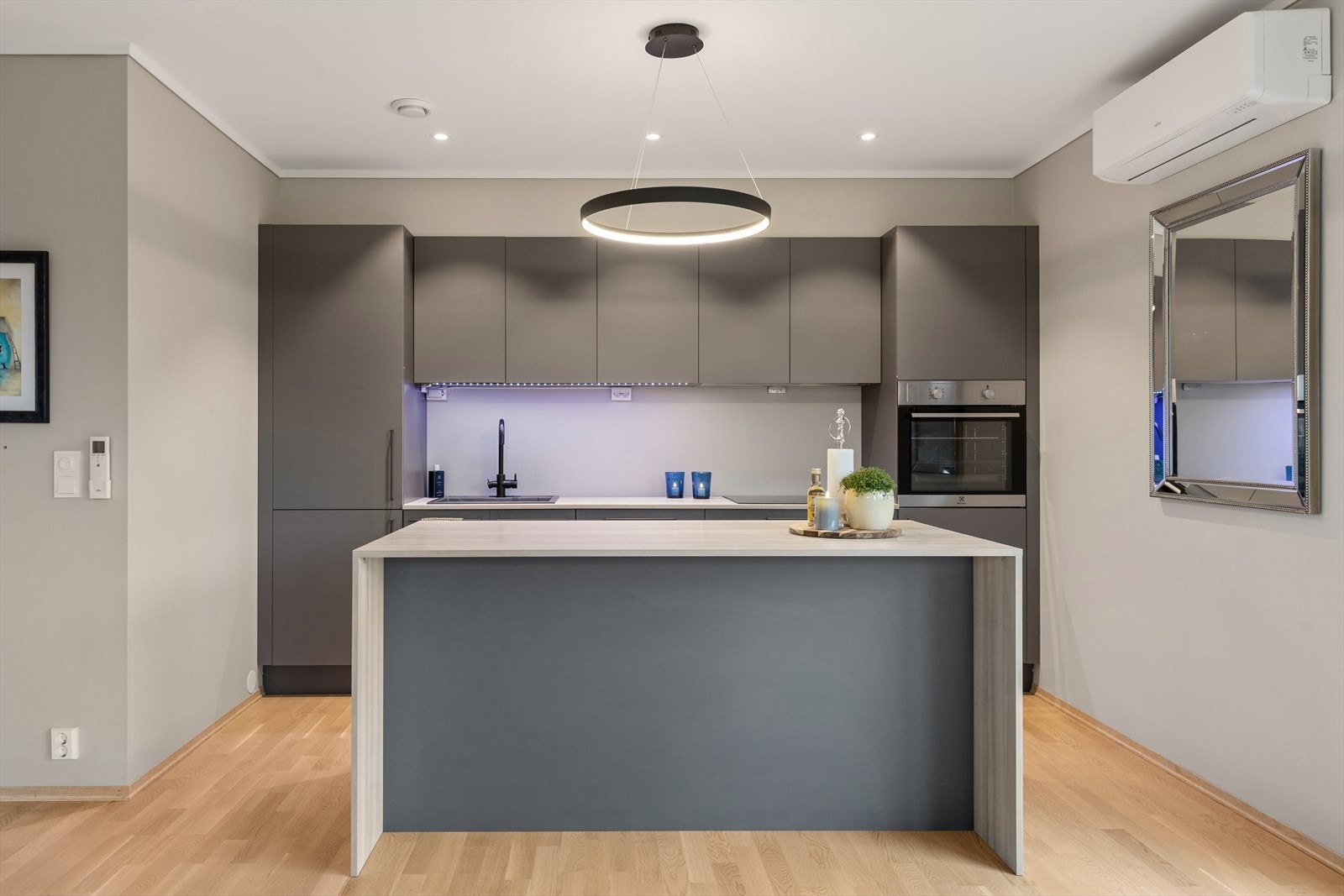 Kjøkkenøya fungerer som en naturlig romdeler og tilbyr både ekstra arbeidsflate og en sosial barløsning. Galleribilde