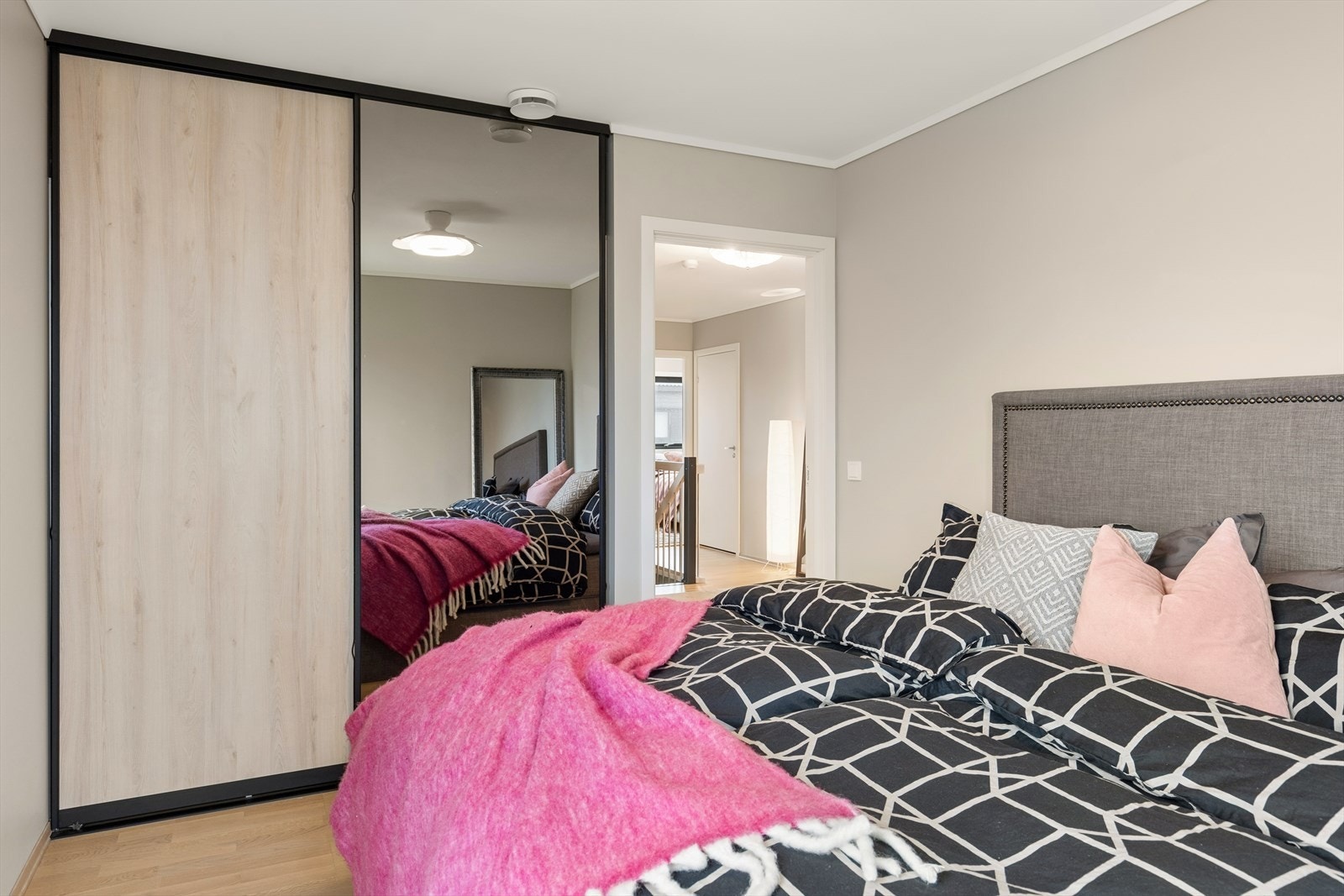 En stor skyvedørsgarderobe med speilfronter gir rikelig med oppbevaringsplass. Galleribilde