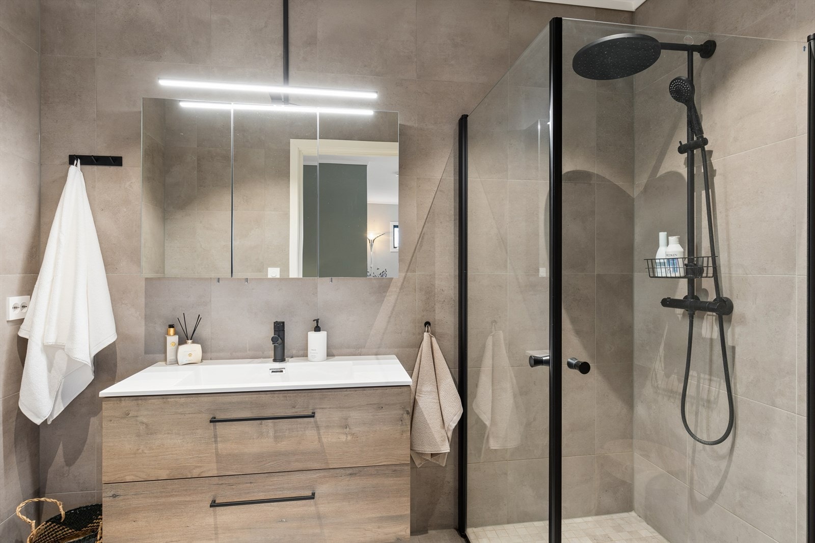 Badet i første etasje er stilrent med flislagte overflater, varmekabler og downlights i taket. Galleribilde