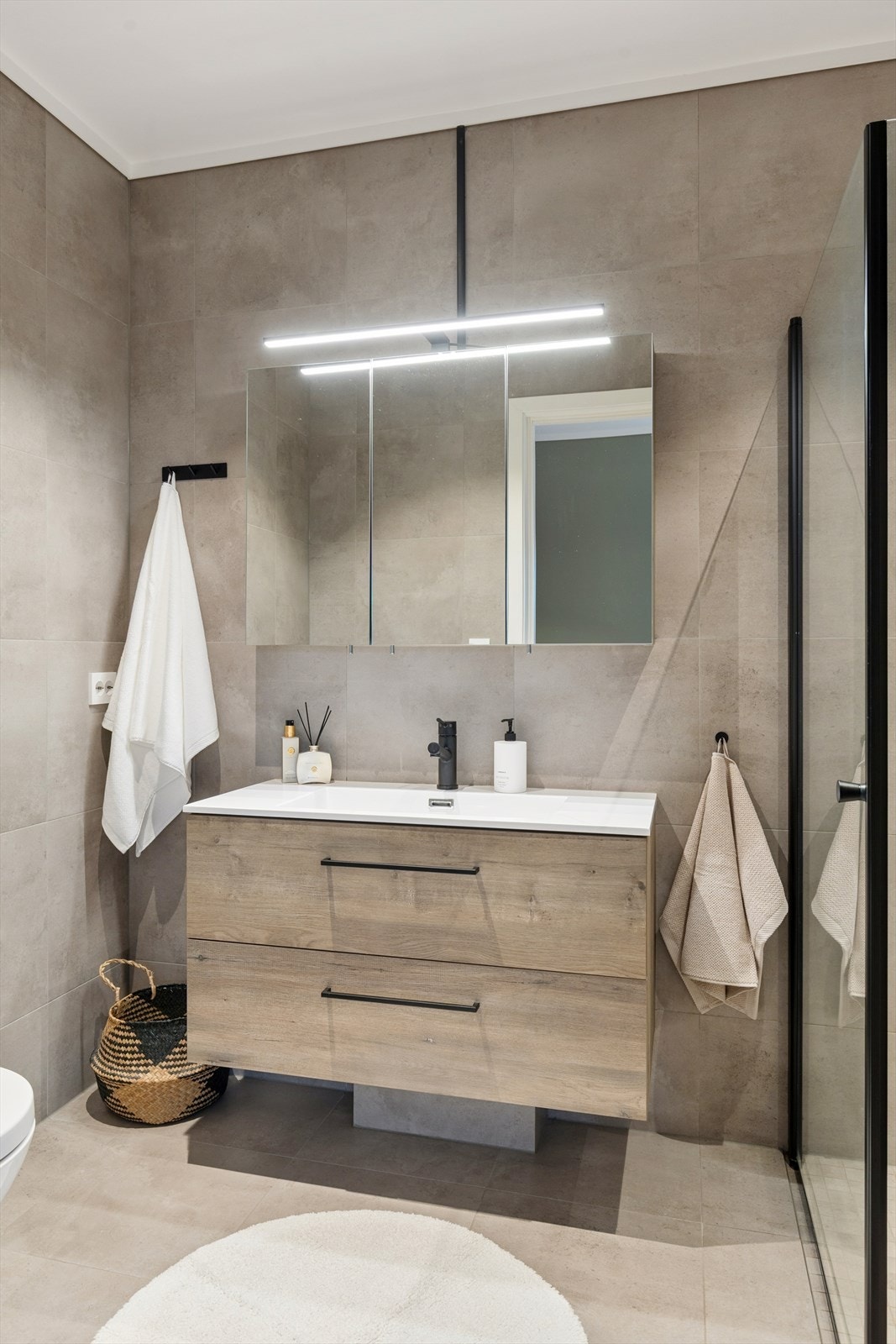 Rommet er utstyrt med servantinnredning, WC og praktiske dusjdører i glass. Galleribilde