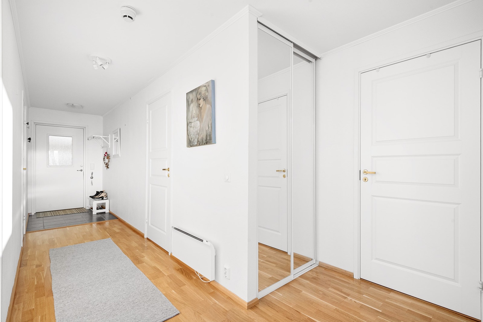 Skyvedørsgarderobe med speilfronter i gangen. Dør til høyre leder til innvendig bod Galleribilde