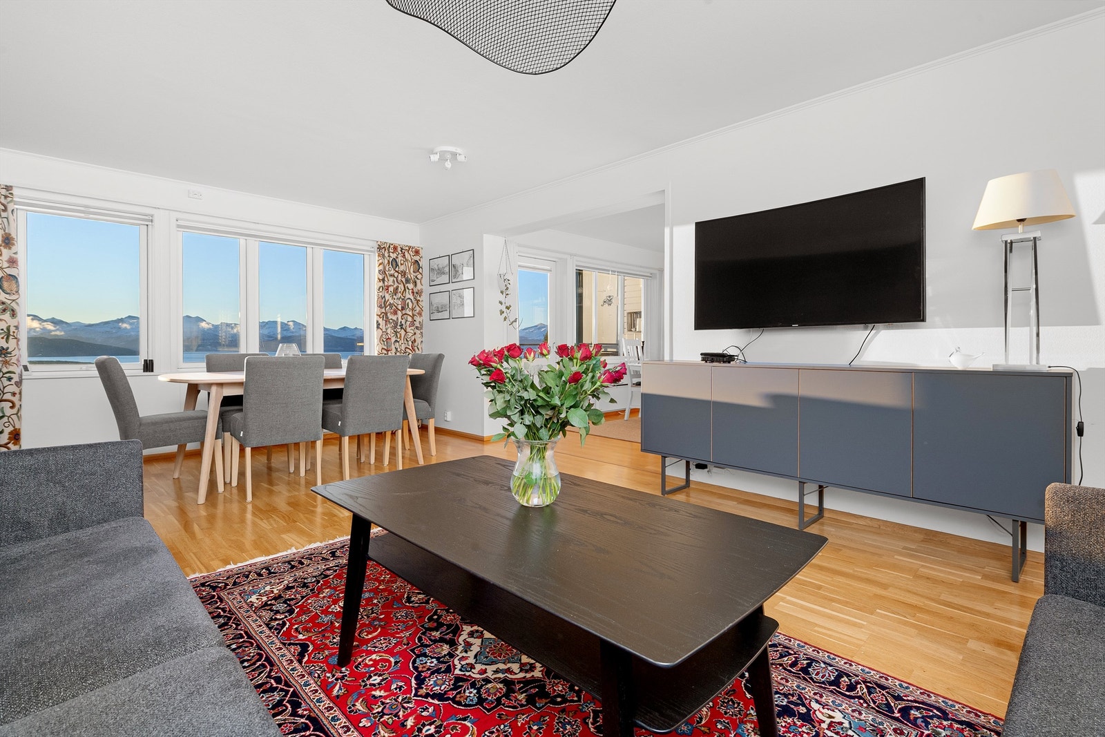 Stue og kjøkken er i åpen løsning med store vindusflater Galleribilde