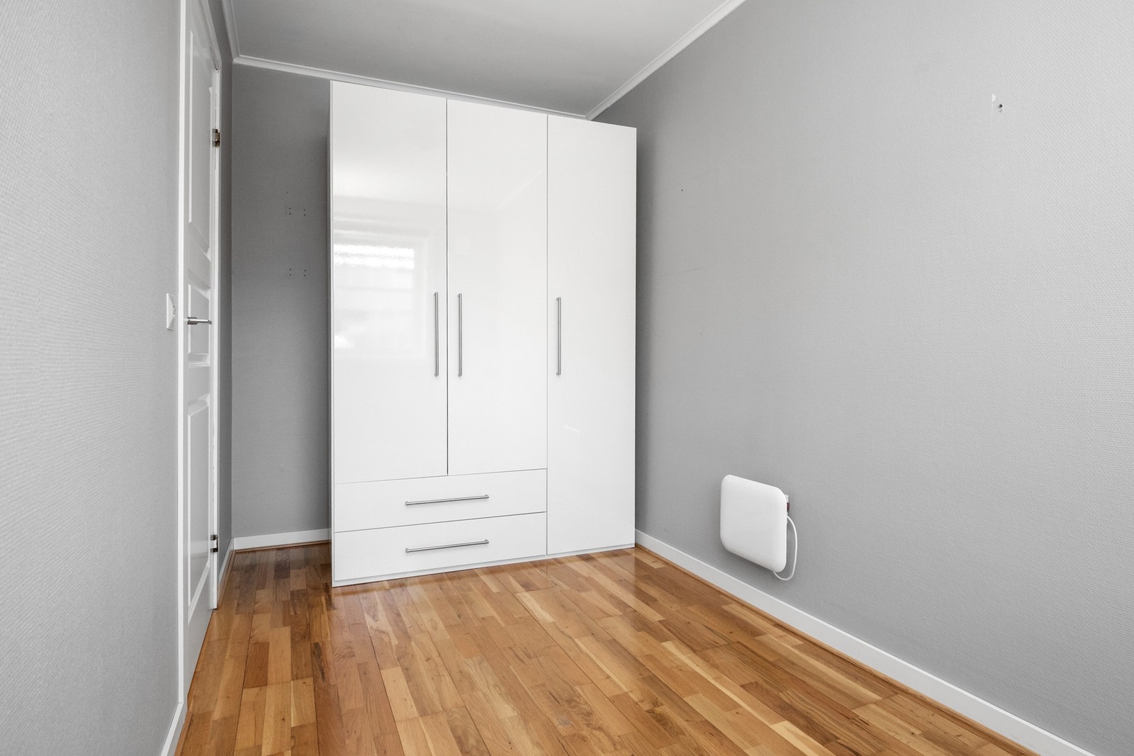 Det er god oppbevaring i et dobbelt garderobeskap med hvitte skuffer og skapfronter Galleribilde