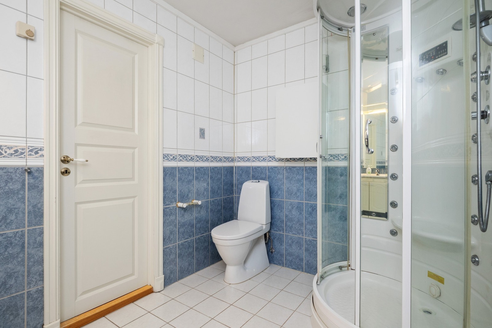 Den øvrige innredningen består av en stor servantbenk med hvite underskap, to matchende veggskap og et speil med belysning Galleribilde