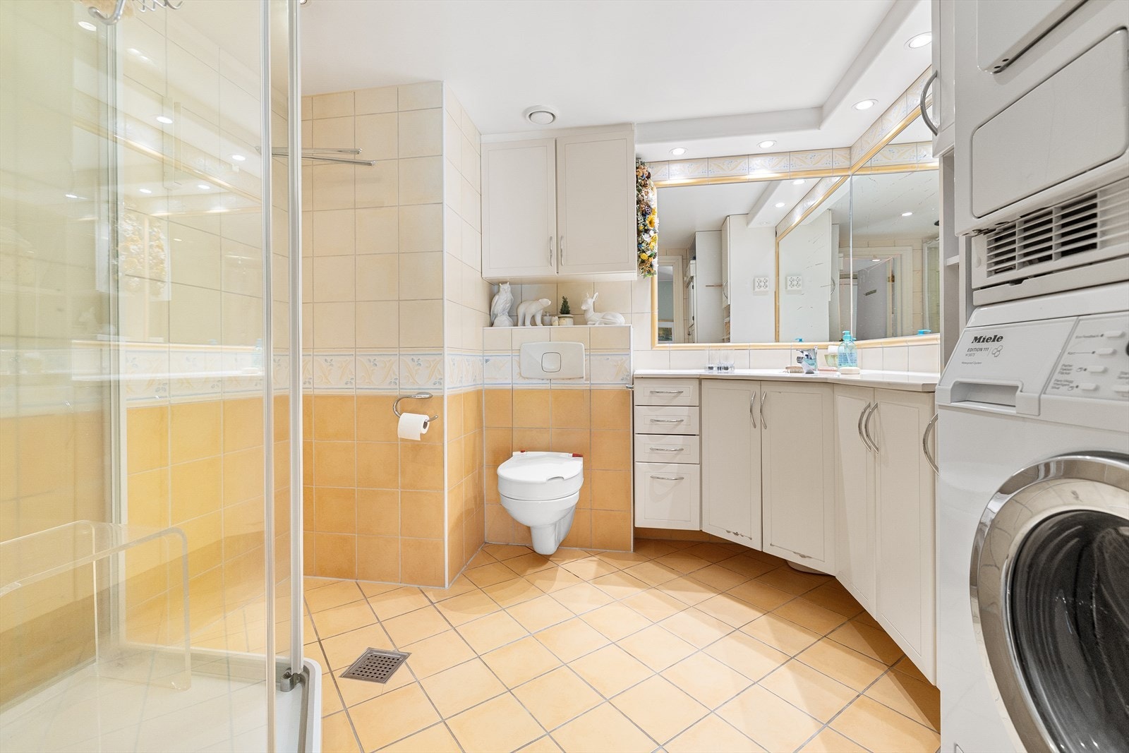 Bad fra byggeår (1998) med flislagte overflater, elektrisk gulvvarme og downlights i himling. Galleribilde