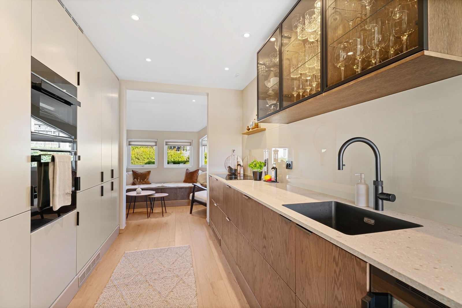 Kjøkkenet ble pusset opp i 2024 og holder en god standard. Her er det en blanding av tre, slette beige fronter og mindre overskap som skaper en luftig følelse Galleribilde