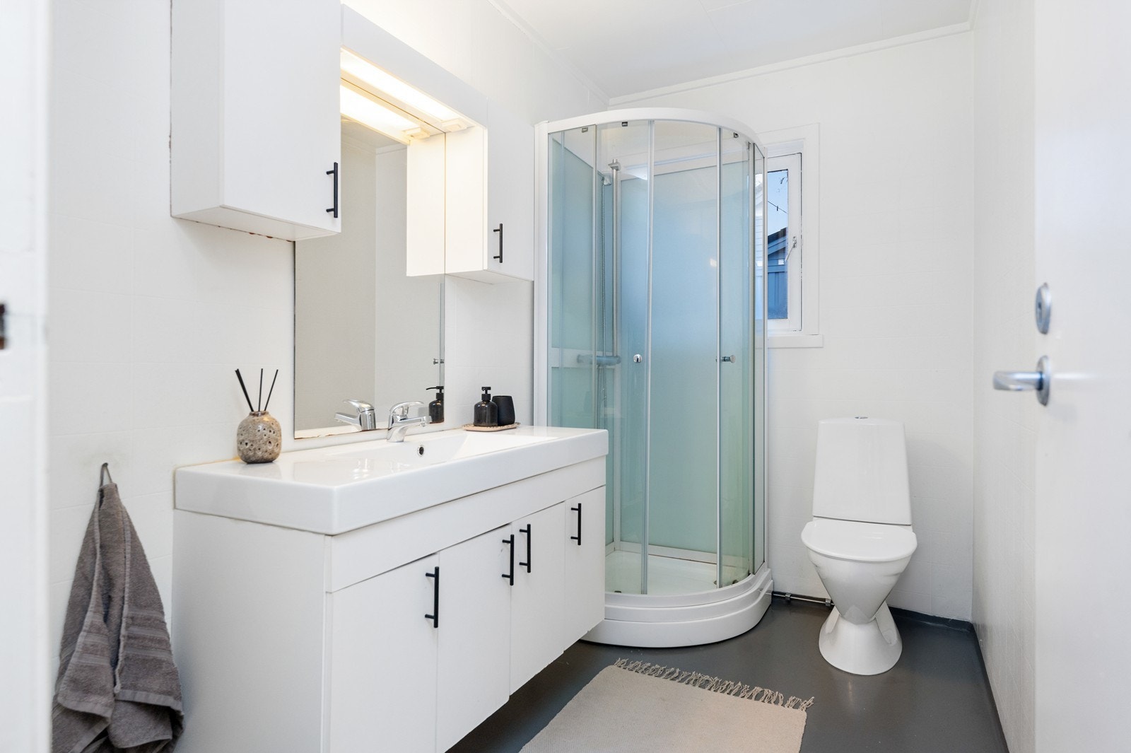 Badet inneholder dusjkabinett, servant og toalett. Galleribilde