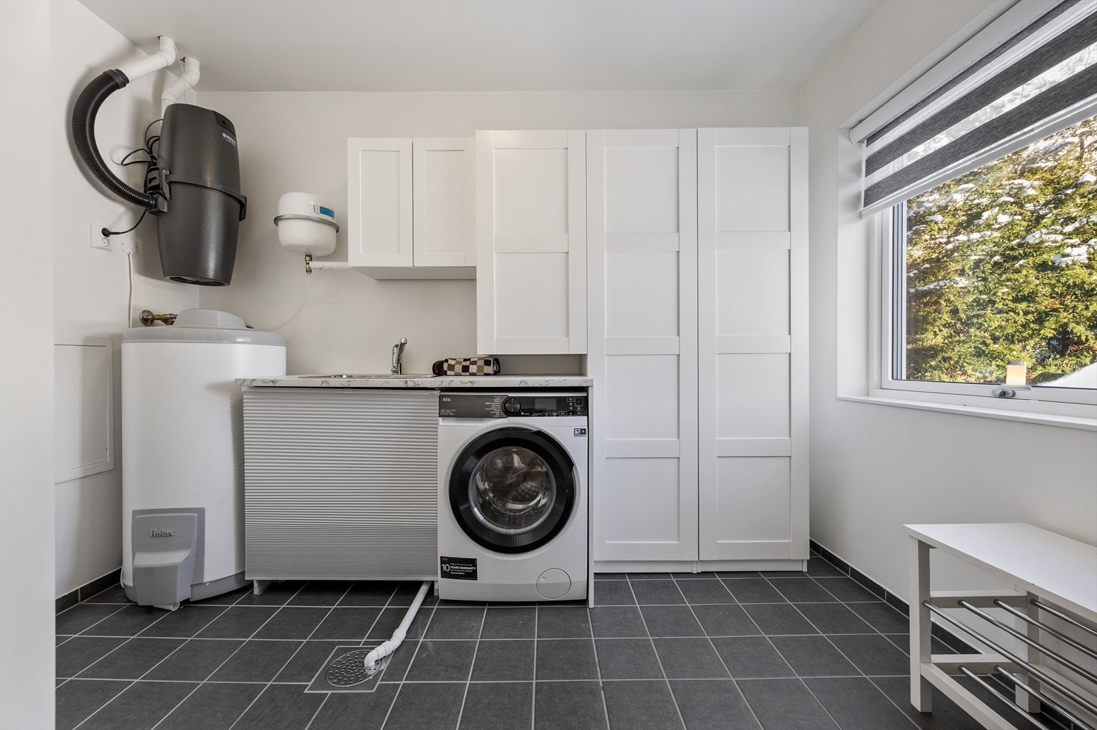 Praktisk og separat vaskerom med oppgradert innredning og utslagsvask i 2025. Tekniske installasjoner som Flexit ventilasjonsanlegg og sentralstøvsuger. Galleribilde