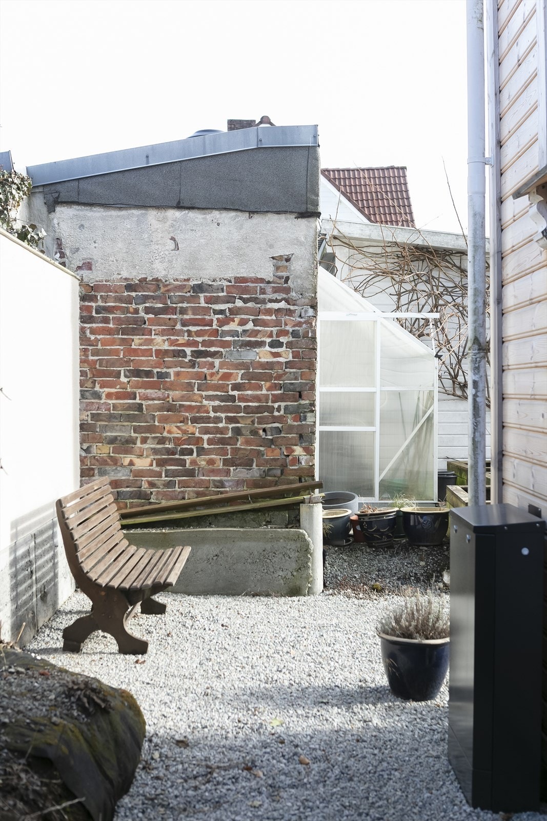 Skjermet og trivelig uteområde med gruslagt plass, levegger og eldre murverk som gir en lun og autentisk atmosfære. Et fint hjørne for sittegruppe, planting eller hobbyprosjekter. Galleribilde