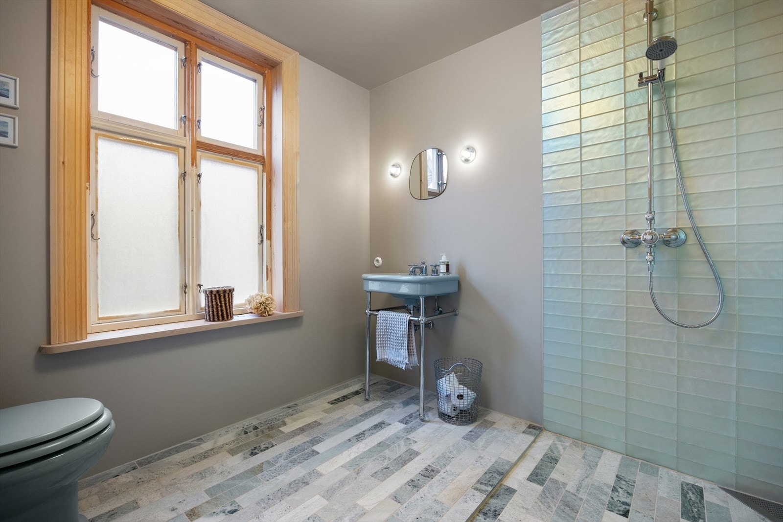 Rommet inneholder servant, veggmontert toalett og dusjvegger/-hjørne. Ventilasjonen er naturlig. Galleribilde