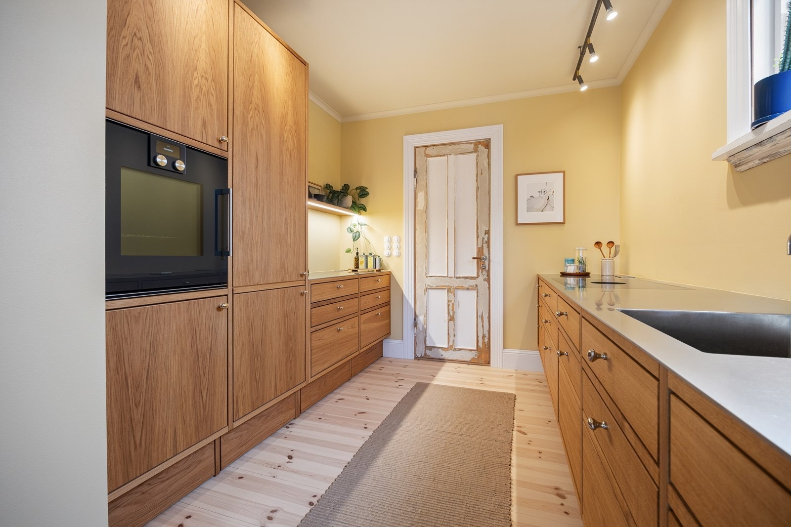 Påkostet og eksklusivt, håndlaget kjøkken med slette fronter fra Frode Tingbø, med skjøtefri benkeplate i curlet stål. Galleribilde