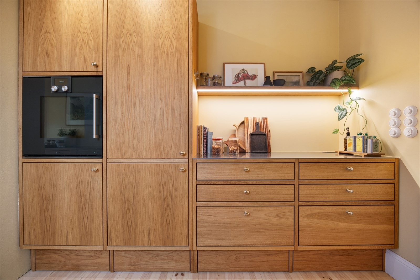 Ferdigstilt i 2024. Innrammet kjøkken i oljet eik og legg merke til klassiske møbelknotter i blankforkrommet messing. Galleribilde