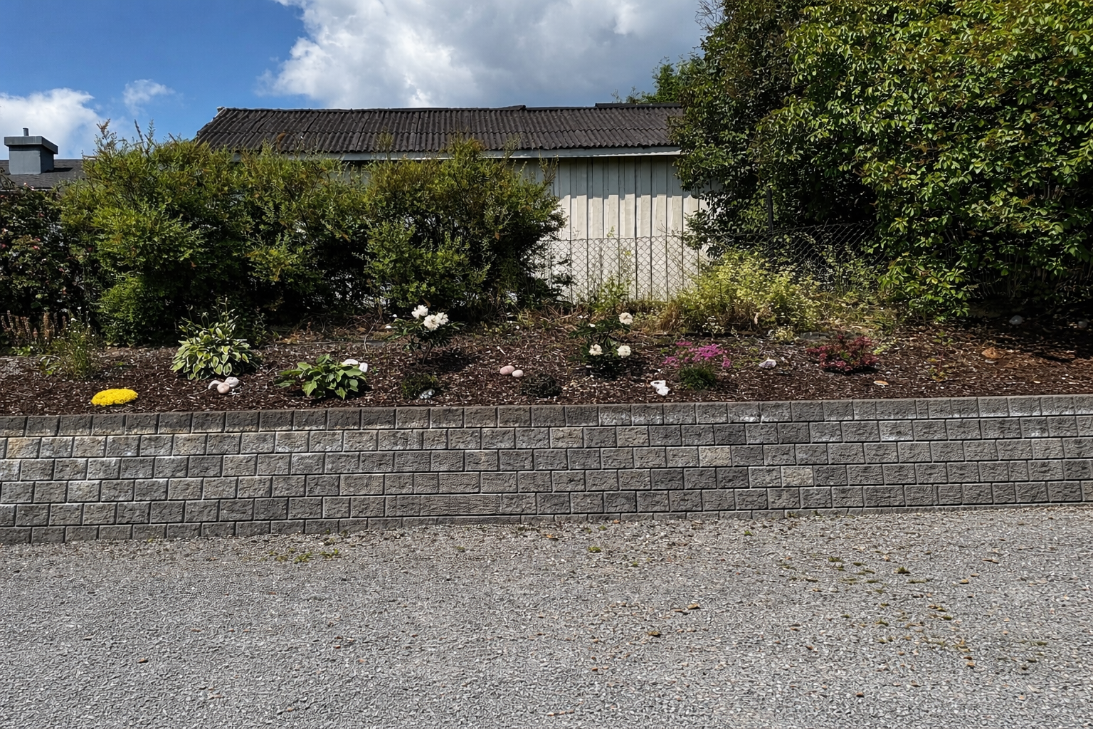 Uteområdene er pent opparbeidet med stenmur og rikt beplantet med stauder. Galleribilde