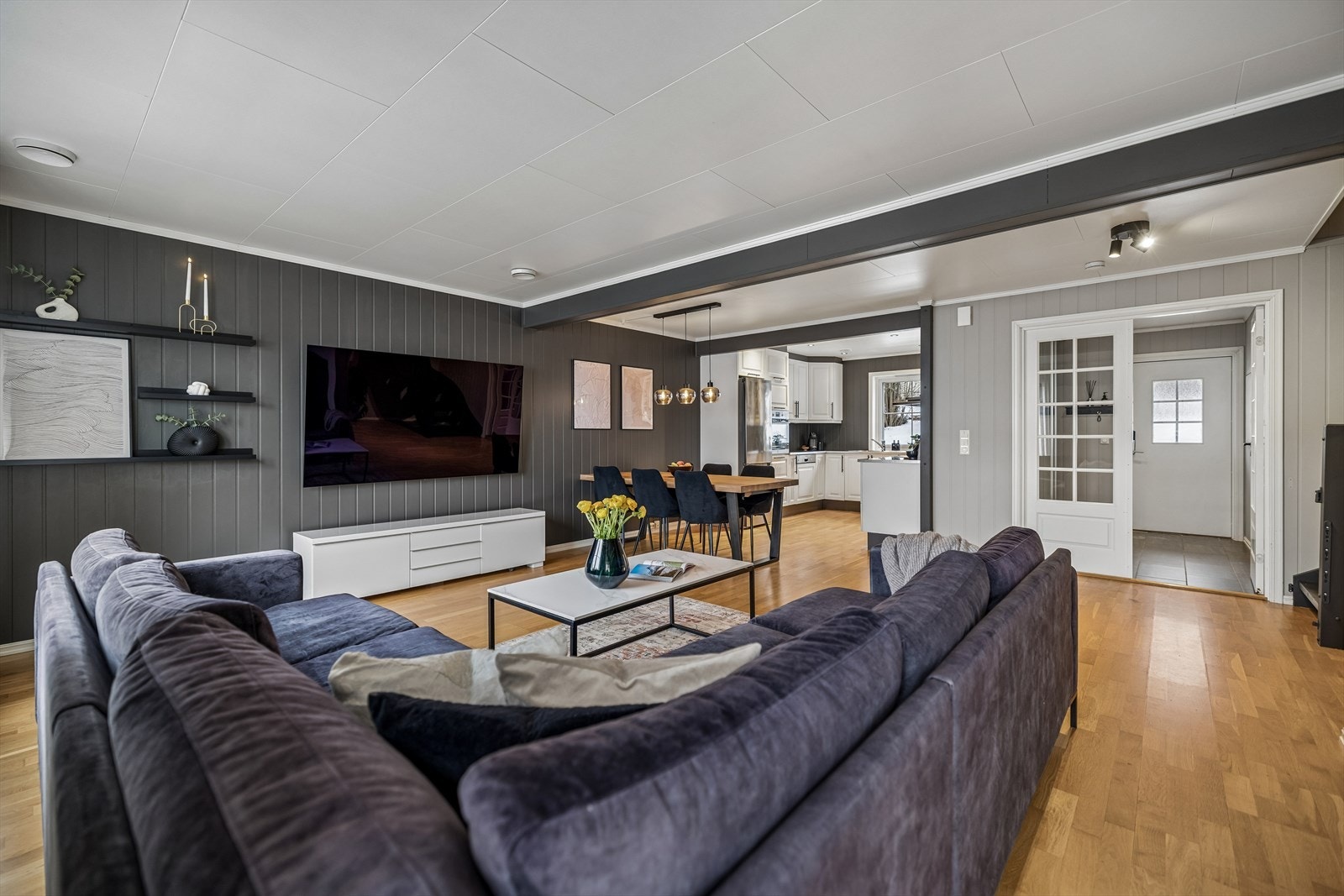 En åpen løsning mellom stue og kjøkken skaper en sosial og luftig atmosfære. Galleribilde