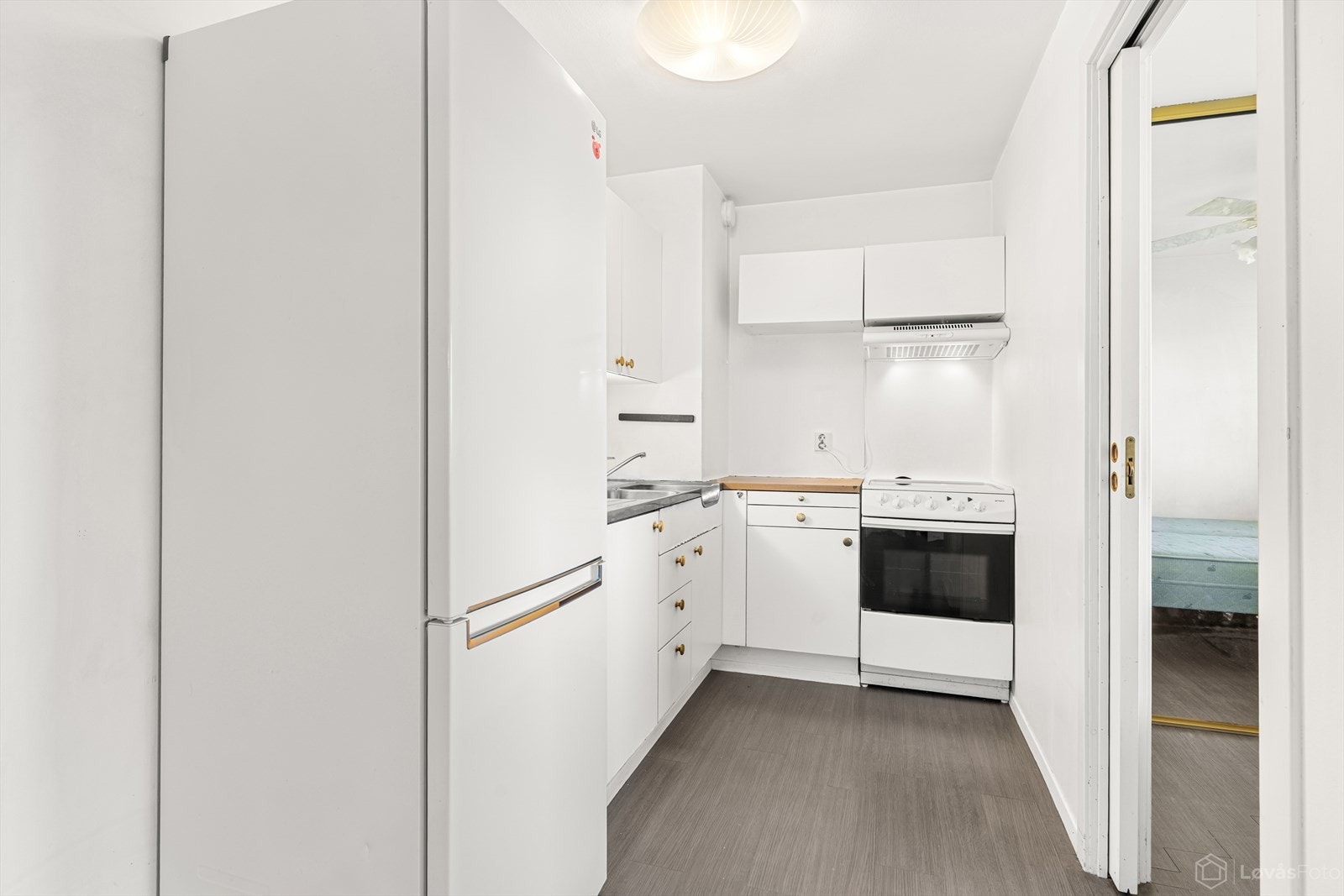 Kjøkkenet har en lys innredning fra byggeåret med glatte fronter og laminat benkeplate med dobbel stålkum. Galleribilde