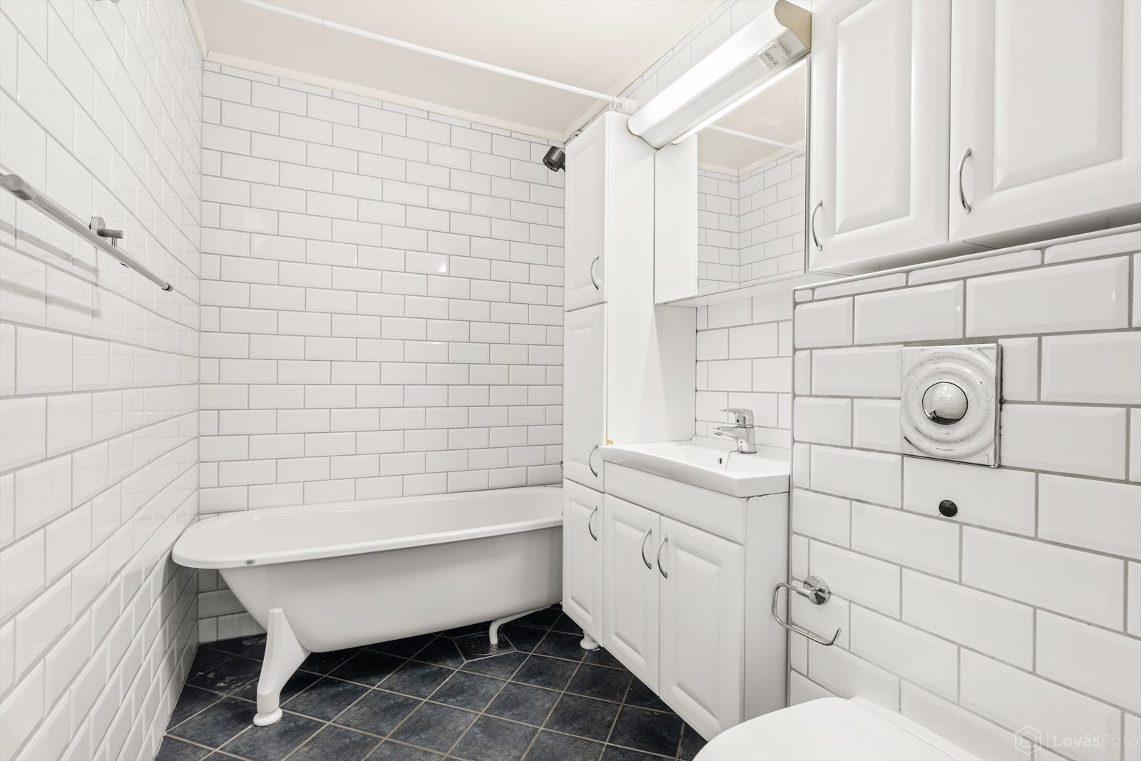 Badet er opplyst oppgradert i 2005 med flislagt gulv og vegger, samt malt himling. Rommet er utstyrt med servantinnredning, badekar, vegghengt WC og opplegg for vaskemaskin. Galleribilde