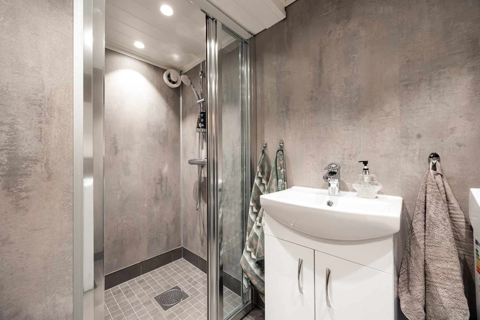 Badet har baderomsplater på veggene, flislagt gulv med elektriske varmekabler og innfelt downlights. Galleribilde