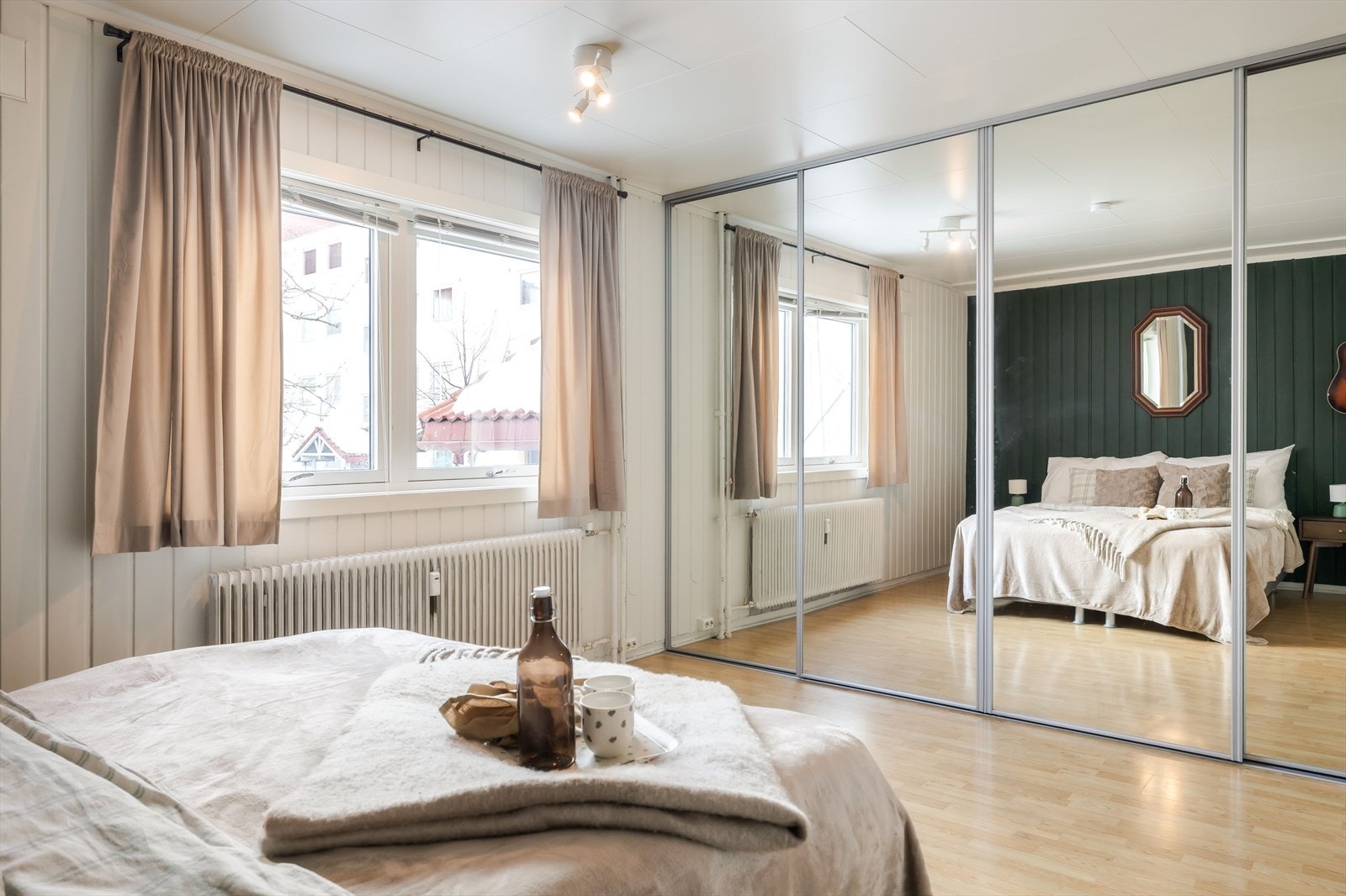 Rikelig med oppbevaringsplass i stor plassbygget skyvedørsgarderobe med speildører langs hele den ene veggen. Galleribilde