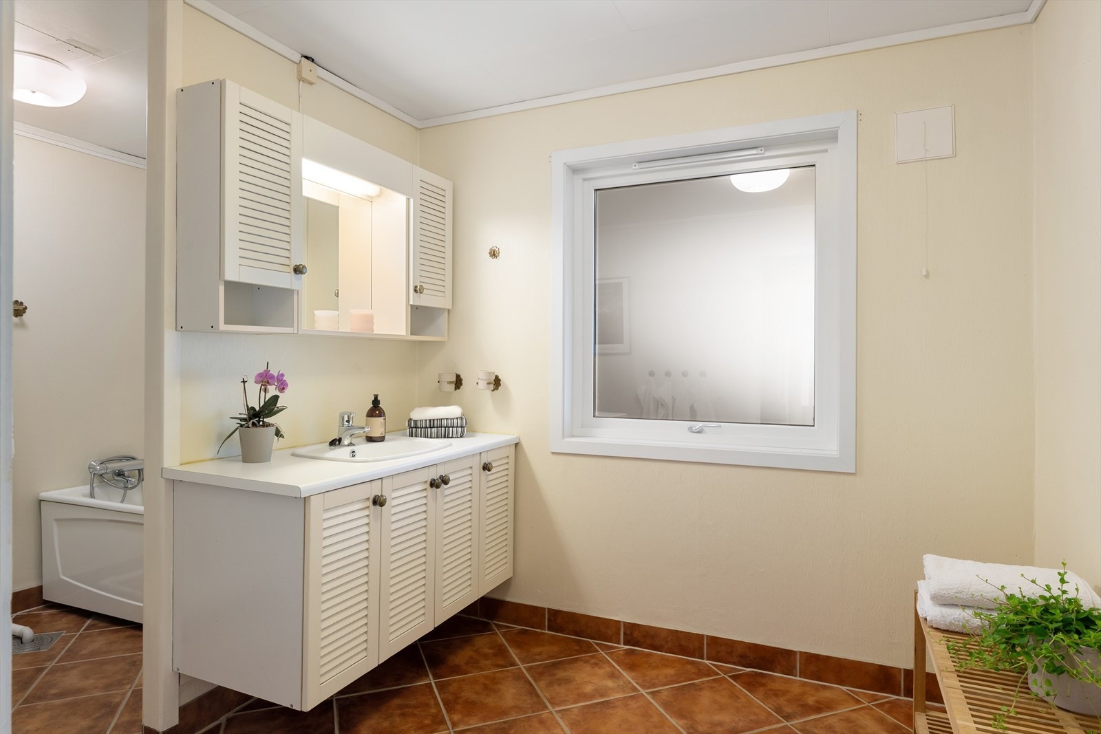 Eldre bad med fliser på gulv og gulvvarme Galleribilde