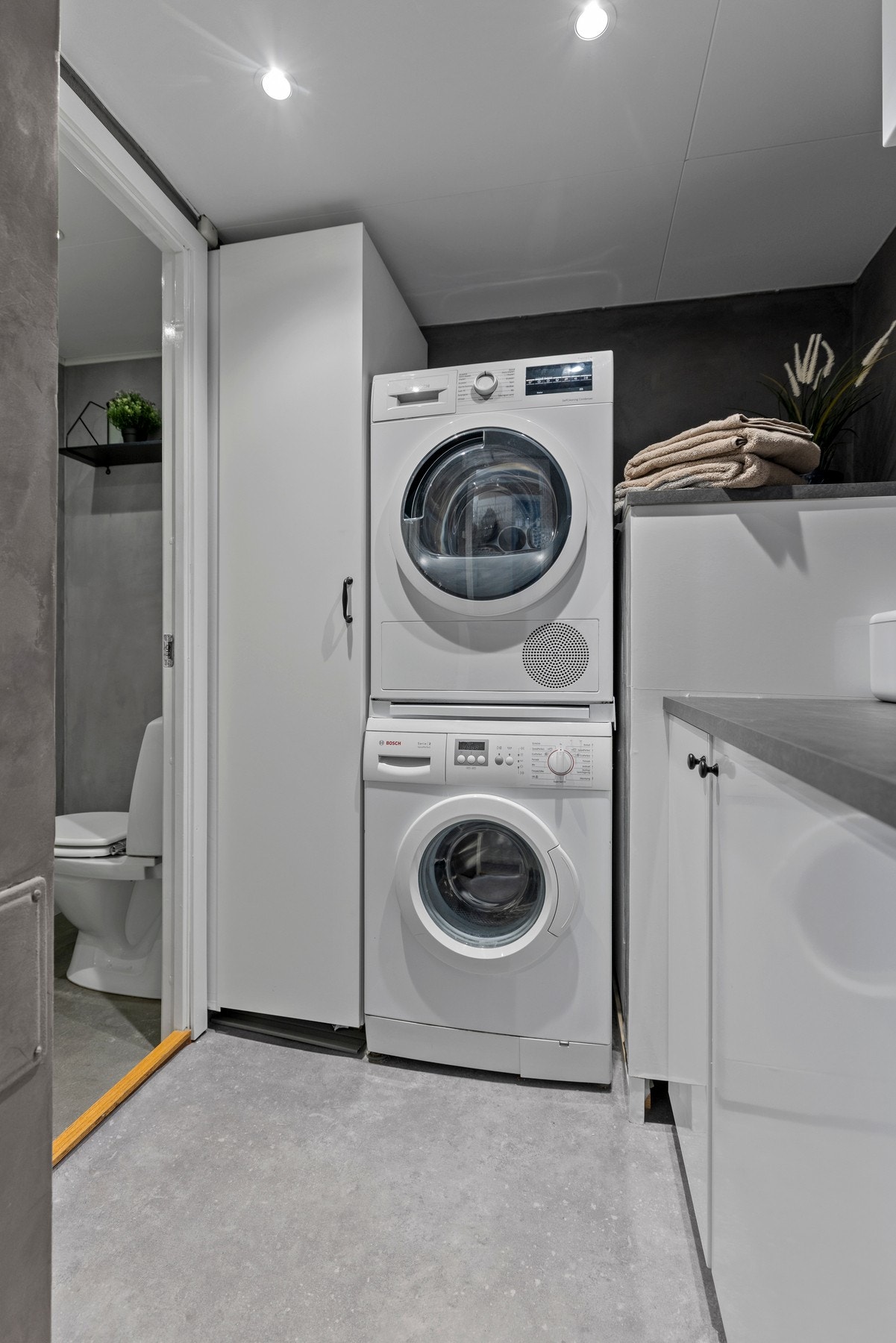 Vaskerommet er utstyrt med opplegg for vaskemaskin og har en innredning med skap med glatte fronter Galleribilde