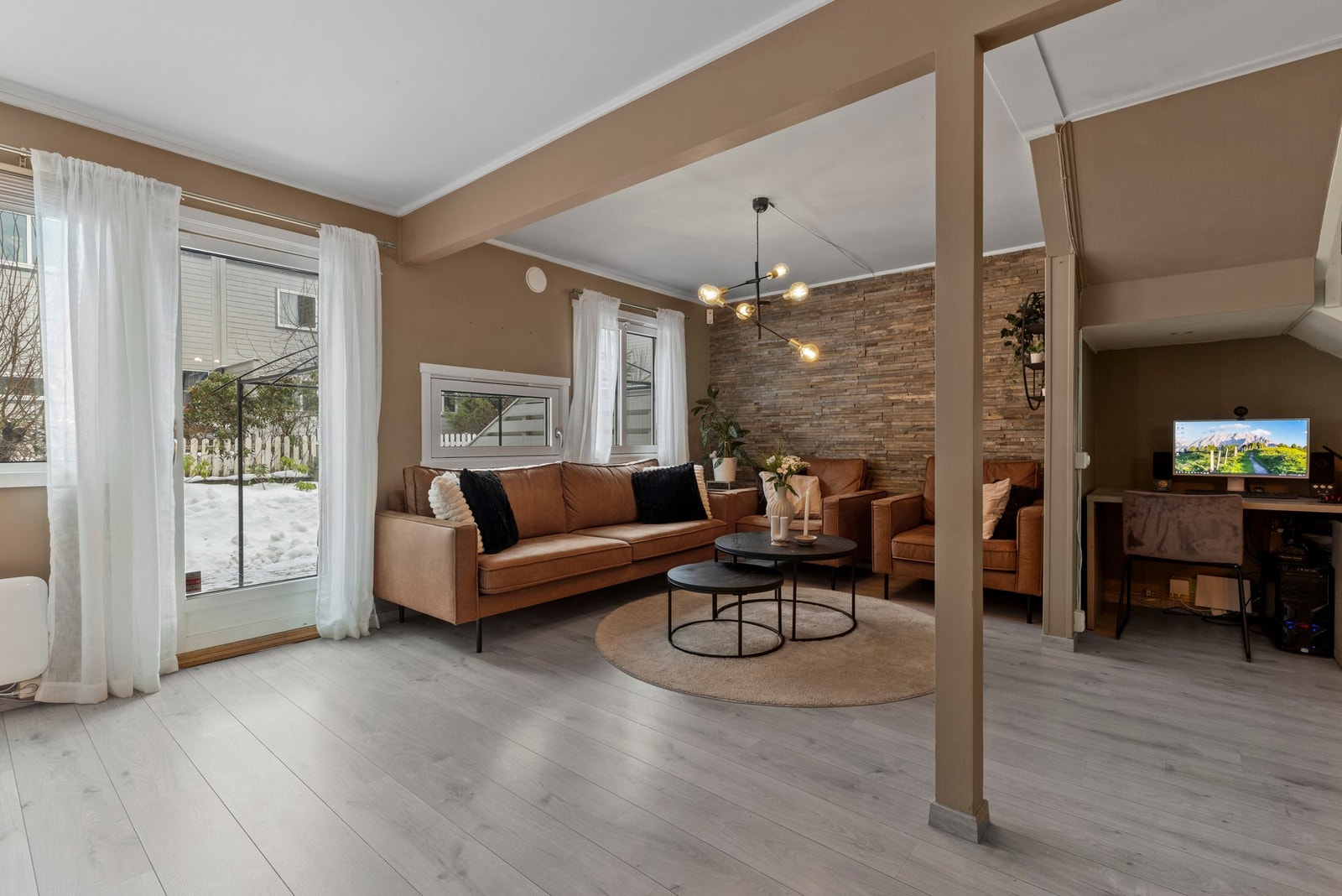 Stuen har pene og moderne overflater med laminatgulv, slette malte vegger, spiler og teglstein Galleribilde