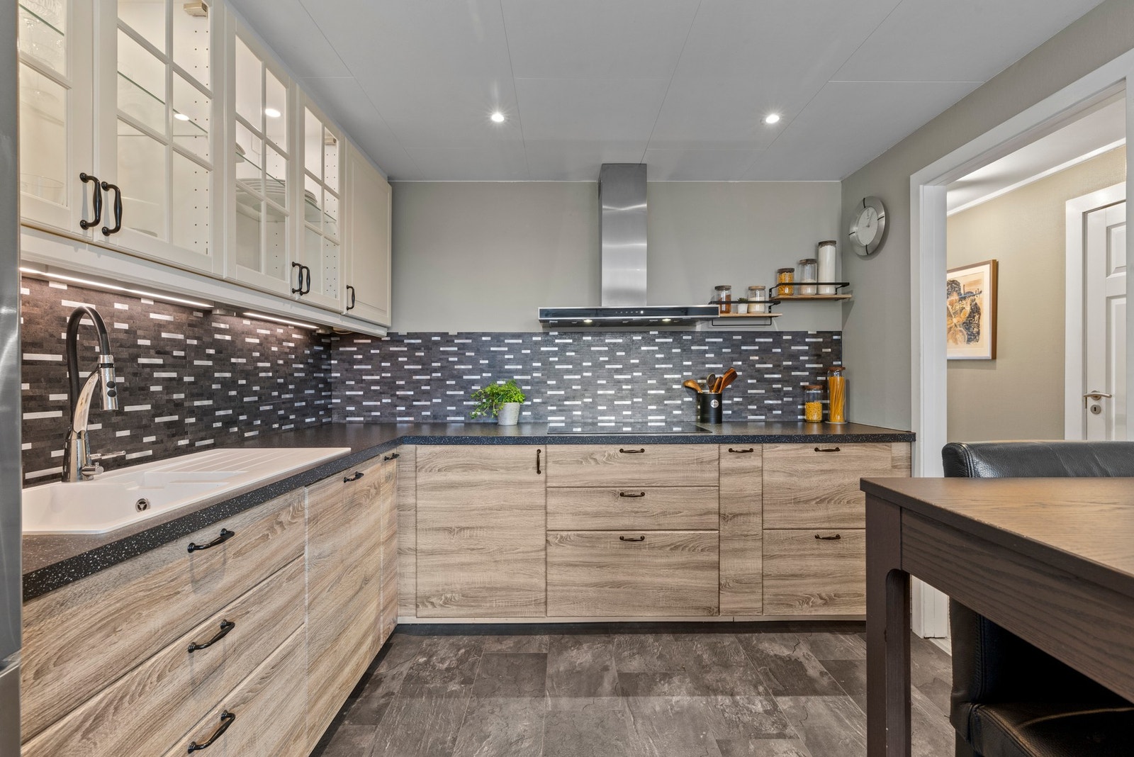 Kjøkkenet har en praktisk innredning med glatte fronter og benkeplate i laminat som gir gode arbeidsflater Galleribilde