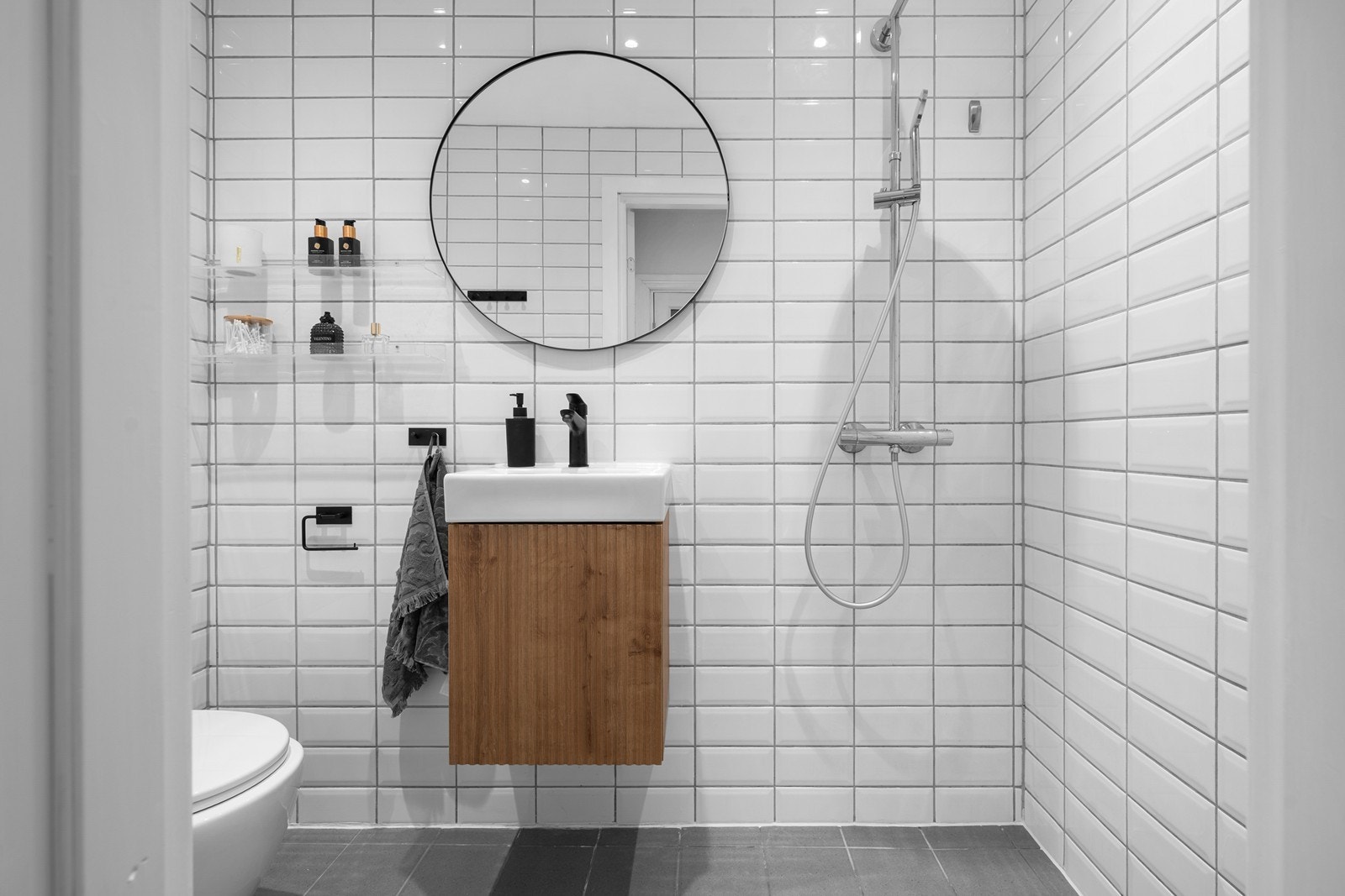 Flislagt bad med vegghengt toalett og en romslig dusjsone. Galleribilde