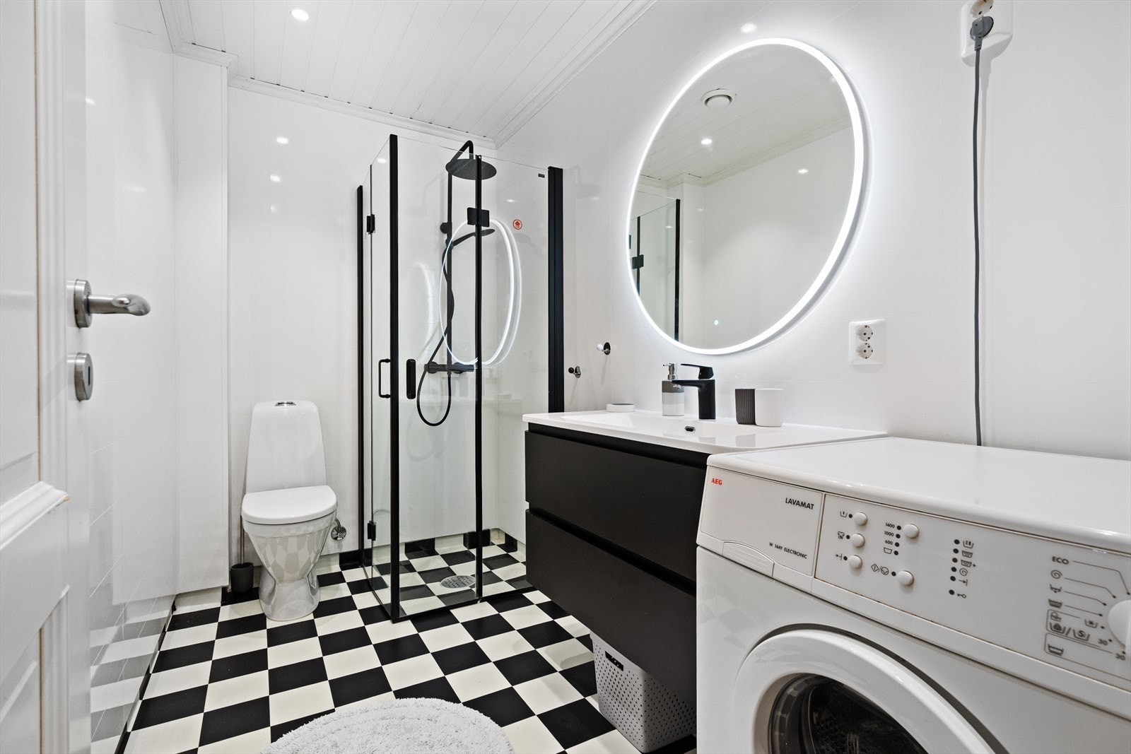 Badet ble pusset opp i 2018. Her er det belegg på gulv, baderomsplater på vegger og panel med spotter i tak. Rommet er praktisk innredet med servant, innfellbare dusjvegger, gulvmontert toalett og mulighet for vaskemaskin. Galleribilde