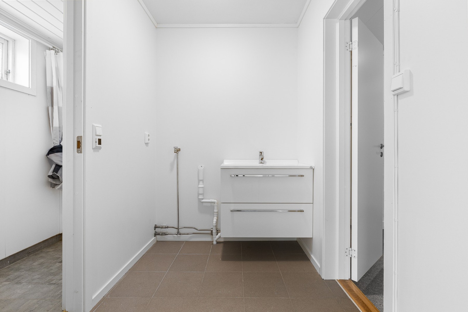 Badet ble pusset opp i 2023 og har baderomsplater på veggene og flislagt gulv med elektriske varmekabler. Galleribilde