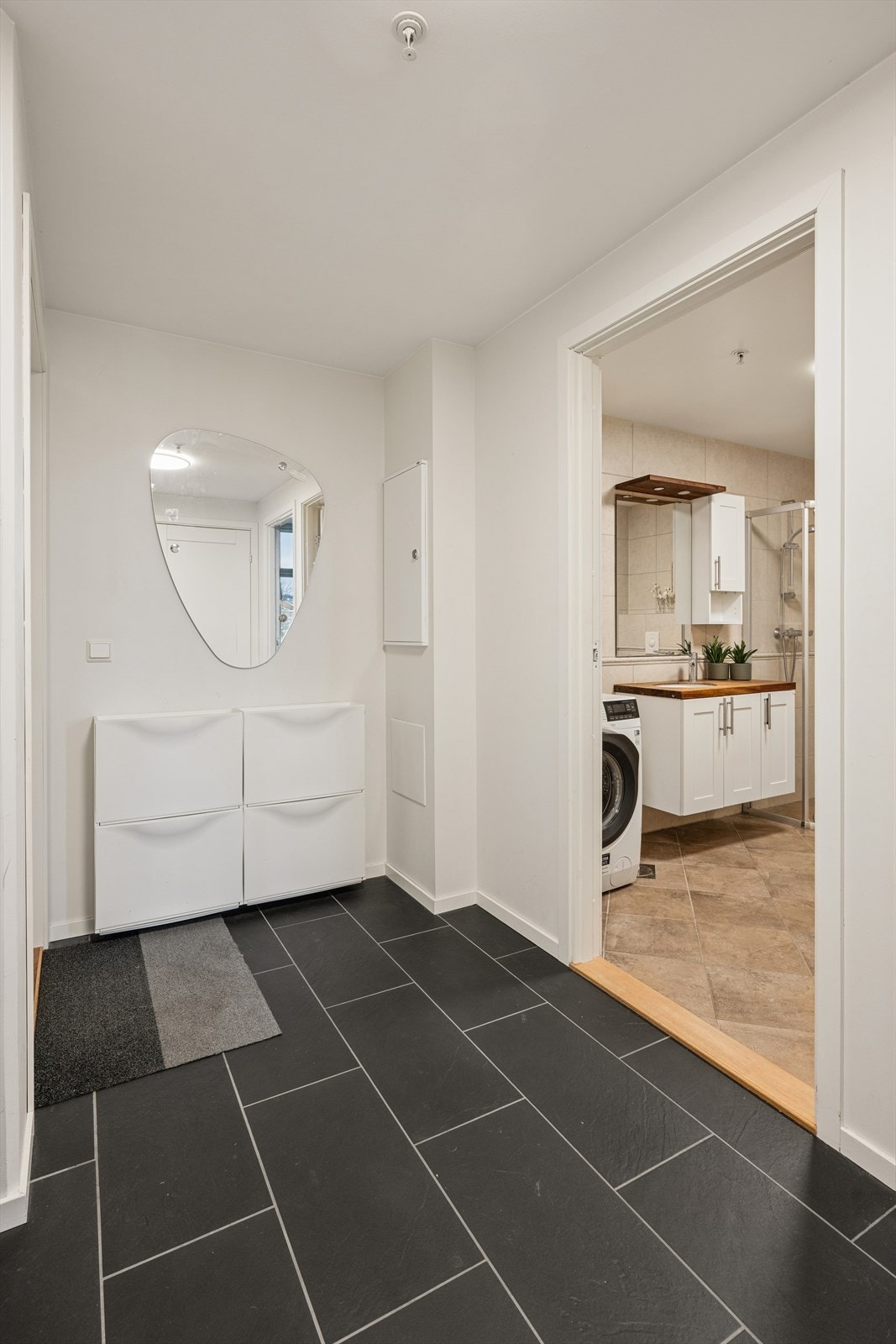 Man ønskes velkommen inn i en lys og romslig entré som er praktisk innredet med flislagt gulv. Her har man god plass til å henge fra seg yttertøy og sko. Galleribilde