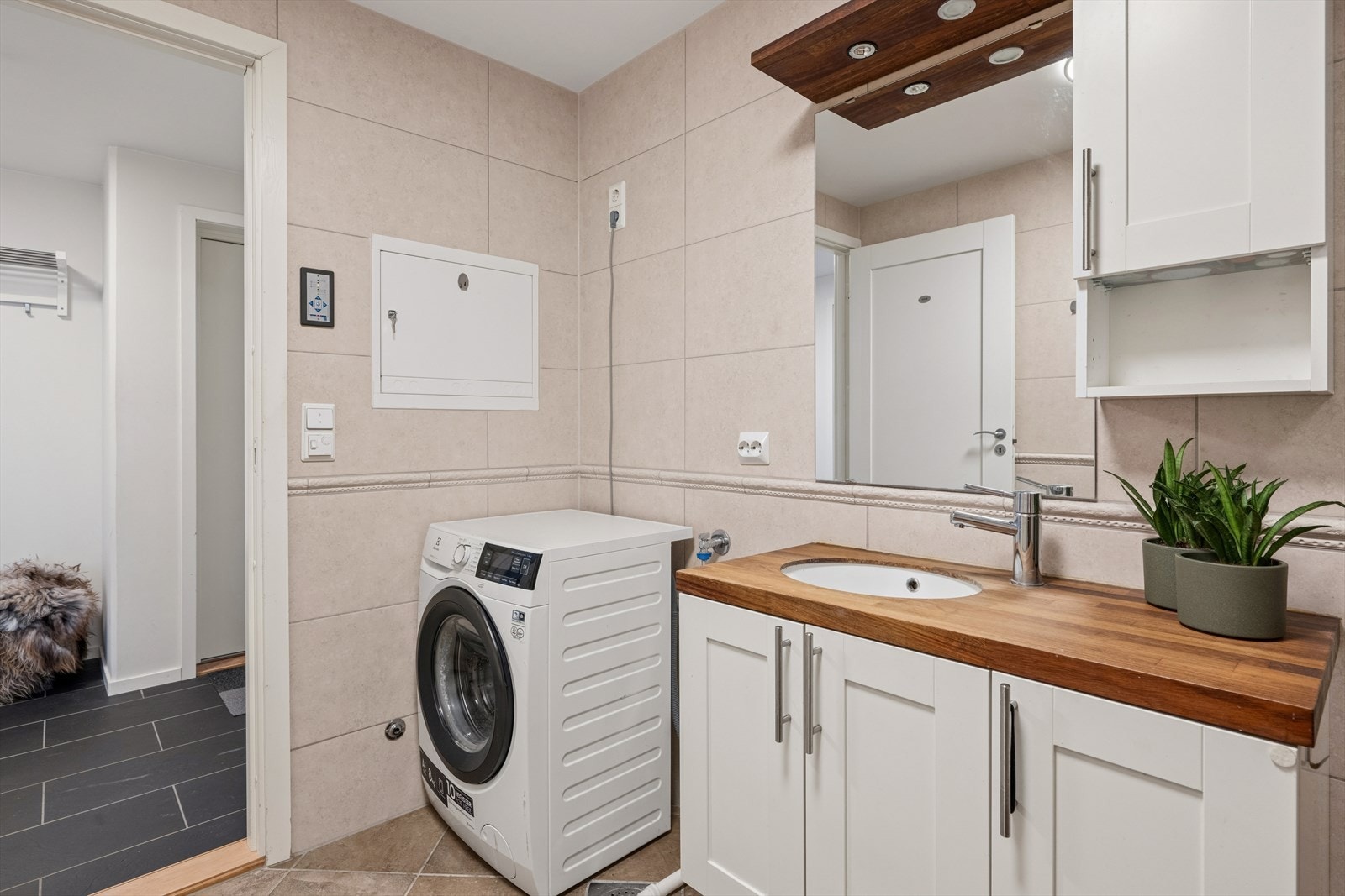 Badet er ellers utstyrt med dusjhjørne, vegghengt toalett og baderomsinnredning med god lagringsplass og nedfelt servant. I tillegg har man opplegg for vaskemaskin. Avtrekk via balansert ventilasjon og tilluft via spalte under dør. Galleribilde