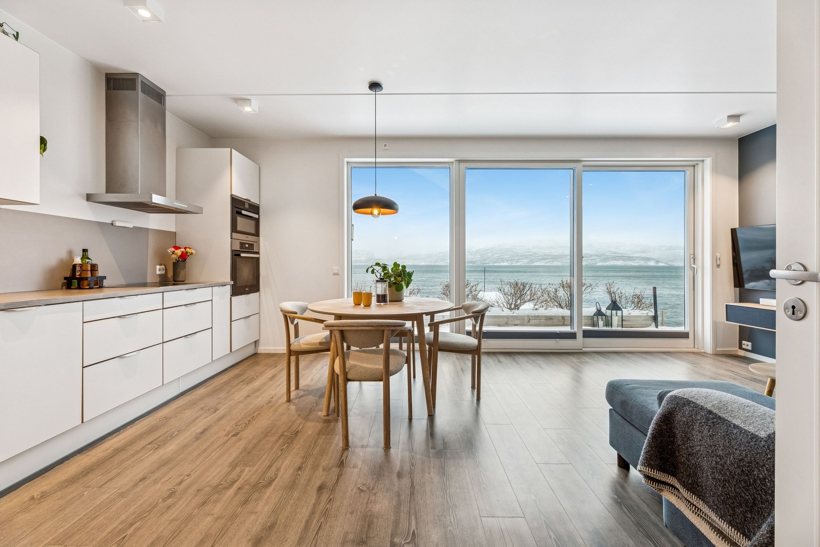 Åpen løsning mellom stue og kjøkken, og store vindusflater som gir godt med lysinnslipp Galleribilde