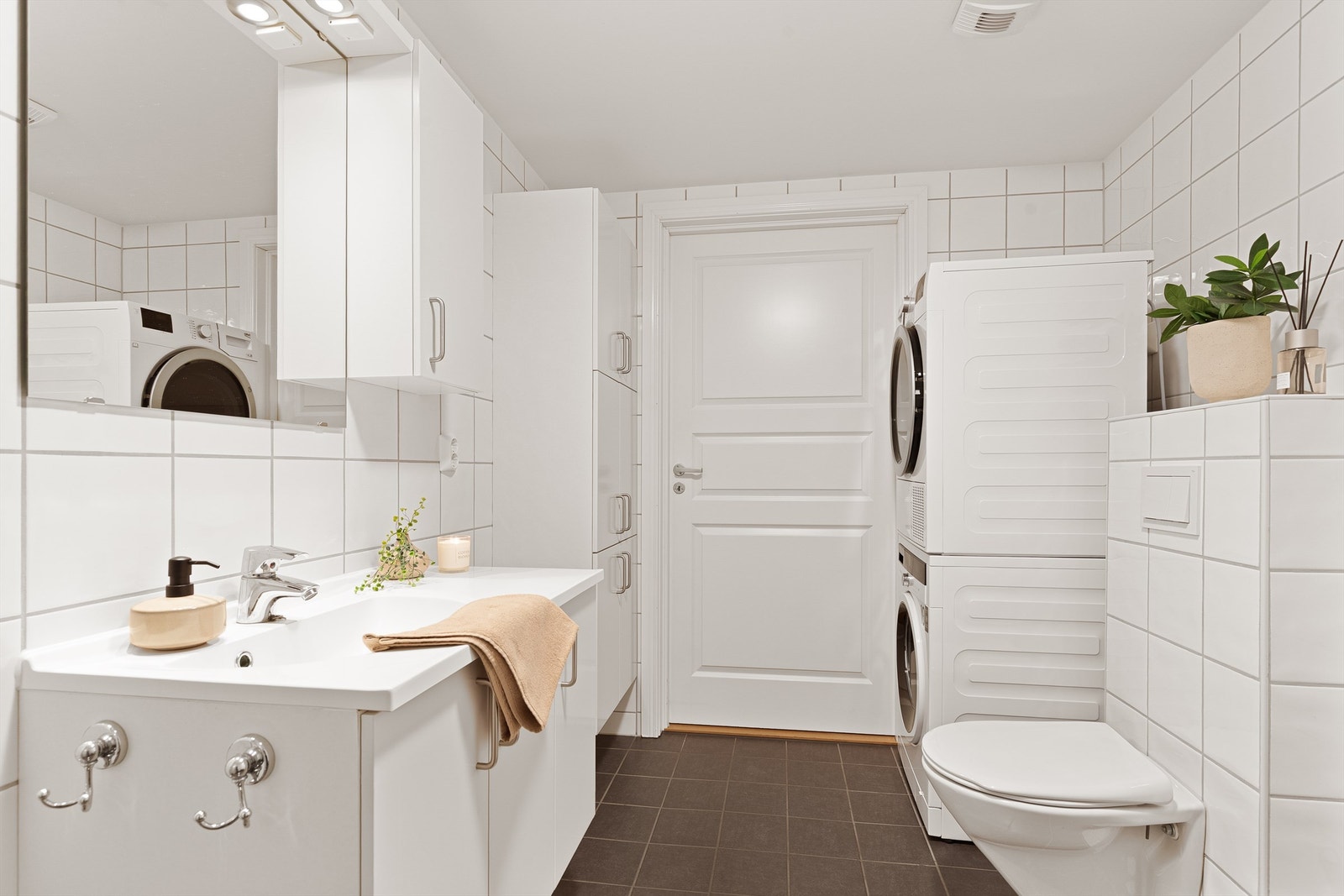 Pent flislagt bad med plass til både vaskemaskin og tørketrommel Galleribilde