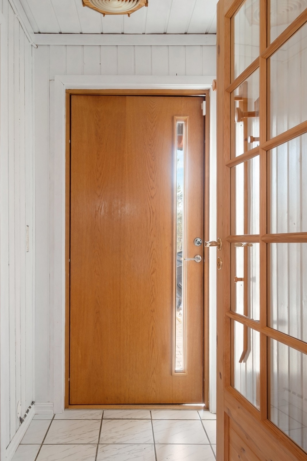 Vel innenfor døren ønsker et flislagt vindfang velkommen med mulighet til å henge fra seg. Galleribilde