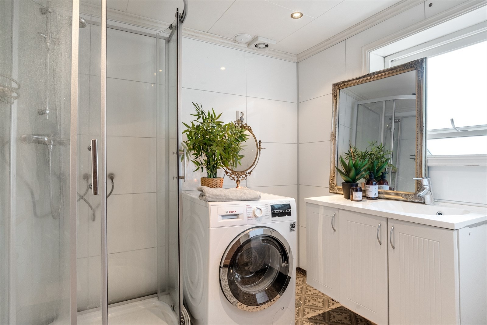 Pent bad med baderomsplater på vegg og vinylbelegg på gulv Galleribilde