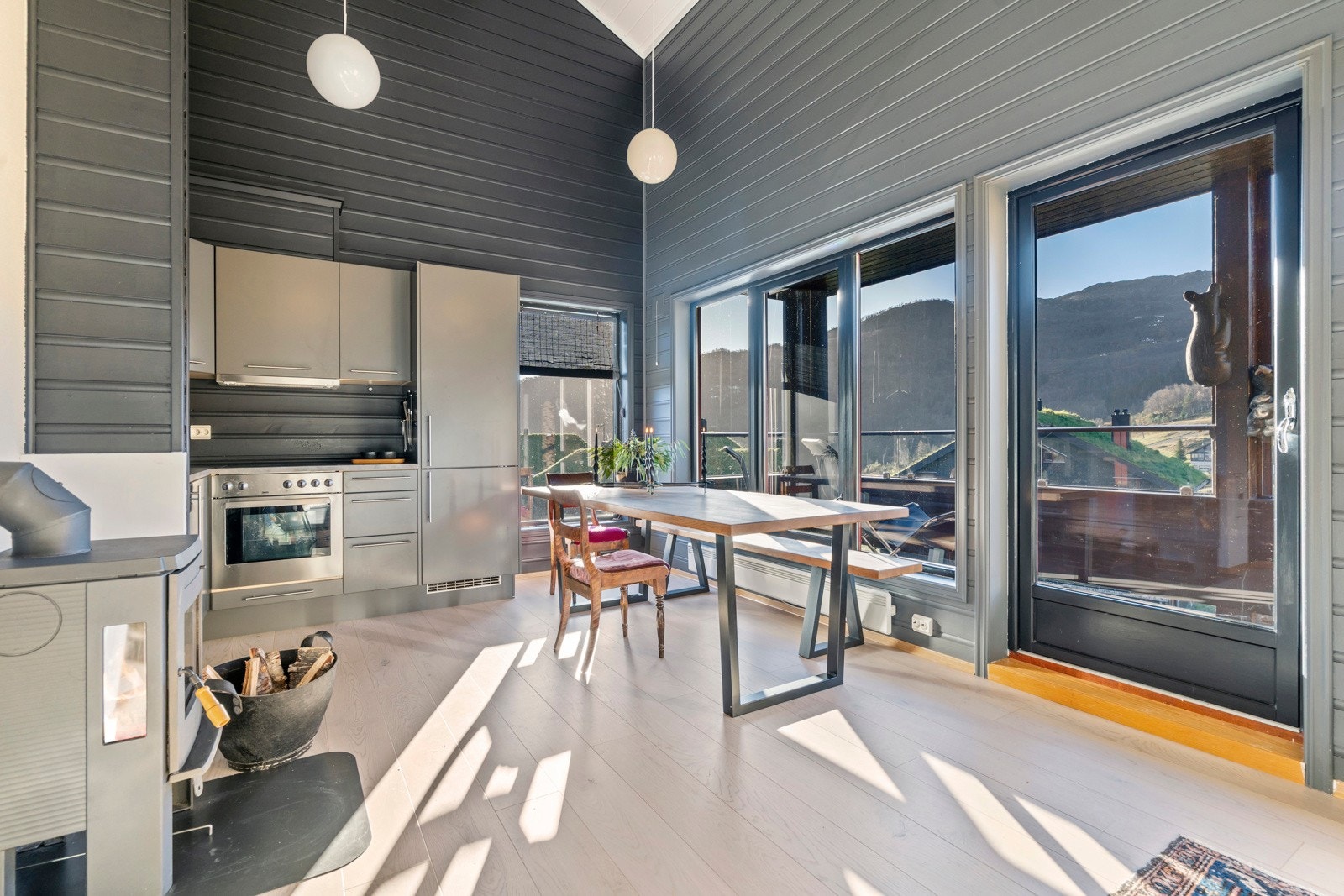 Åpen stue- og kjøkkenløsning med god takhøyde og store vindusflater som slipper inn rikelig med dagslys Galleribilde