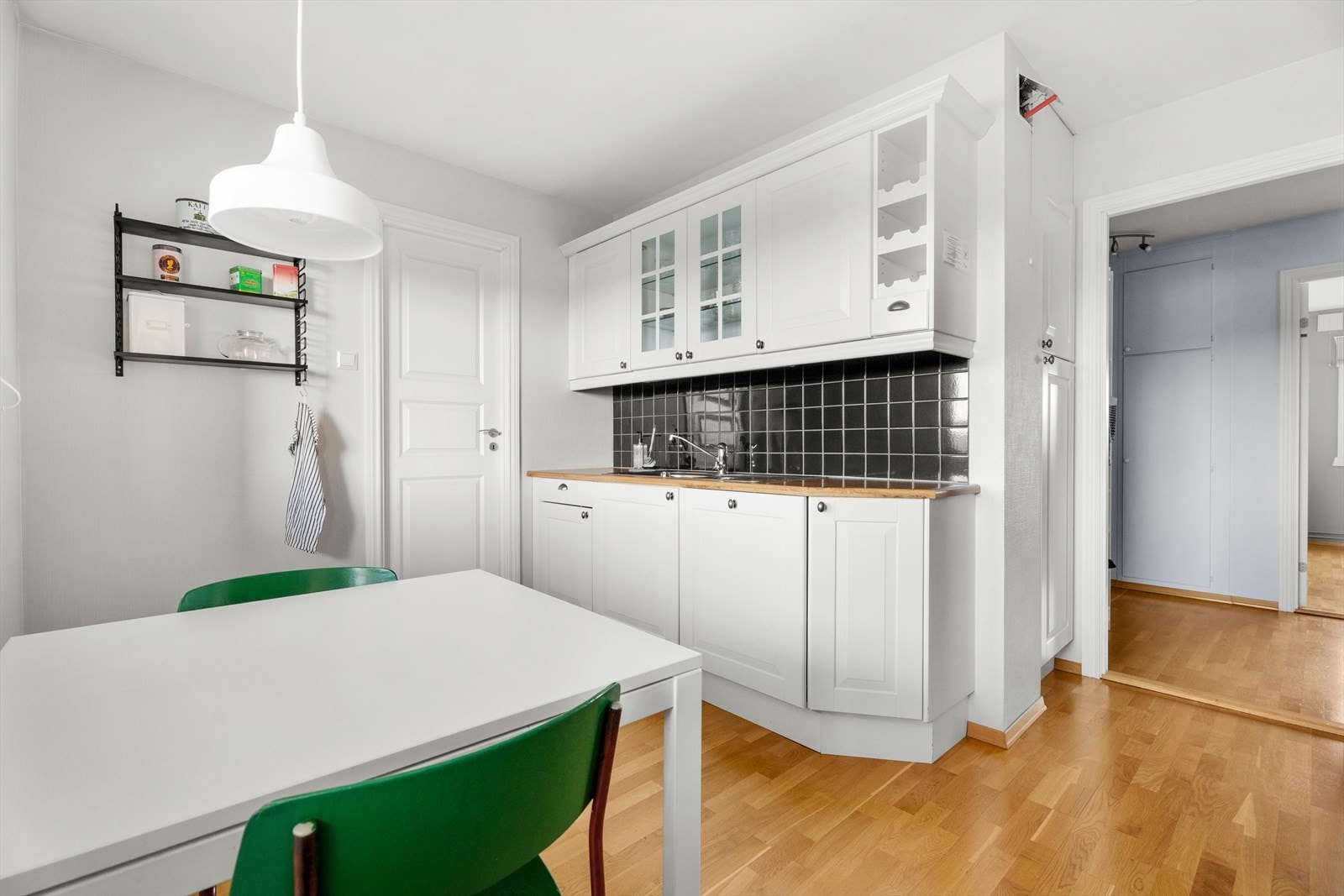 Integrerte hvitevarer som oppvaskmaskin og koketopp kompletterer kjøkkenets utstyr. Galleribilde