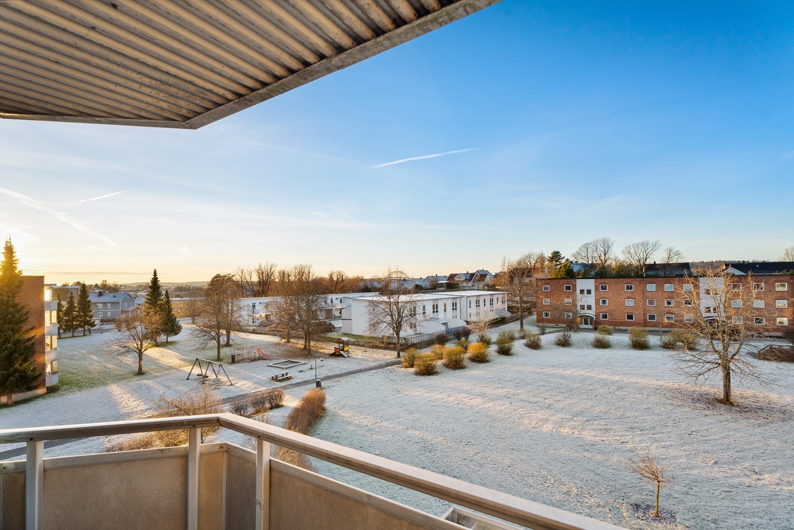 Utsikt fra terrassen mot frodige omgivelser og nabobygg. Galleribilde