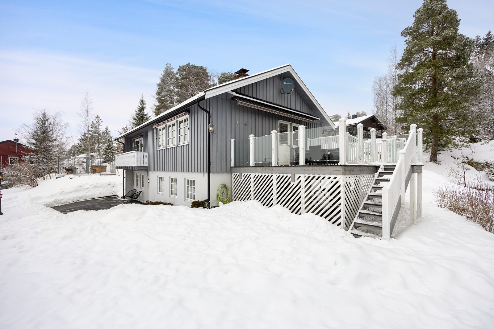 Tomten er skrånende, samt pent opparbeidet med gressplen, prydbusker, hekk og asfaltert gårdsplass. Galleribilde