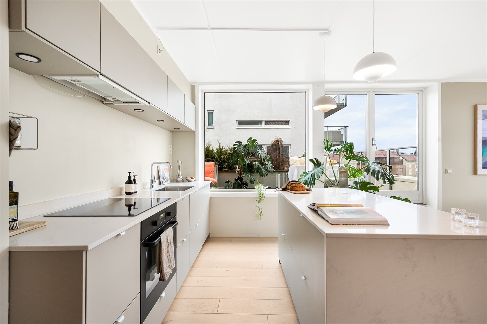 Stilsikker innredning fra 2023 med glatte fronter og benkeplate i kvartskompositt med nedfelt vask. Galleribilde